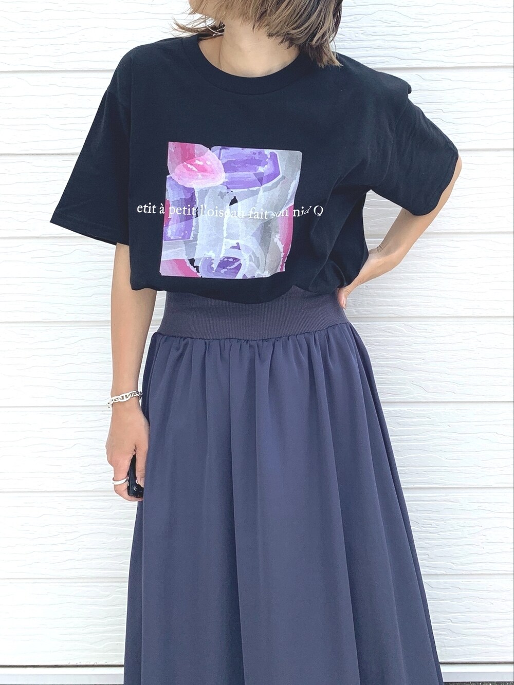 ホワイト系のスニーカー、ブラック系のTシャツ/カットソー、シルバー系のブレスレットを着用したレディースの夏コーディネートの2枚目の写真