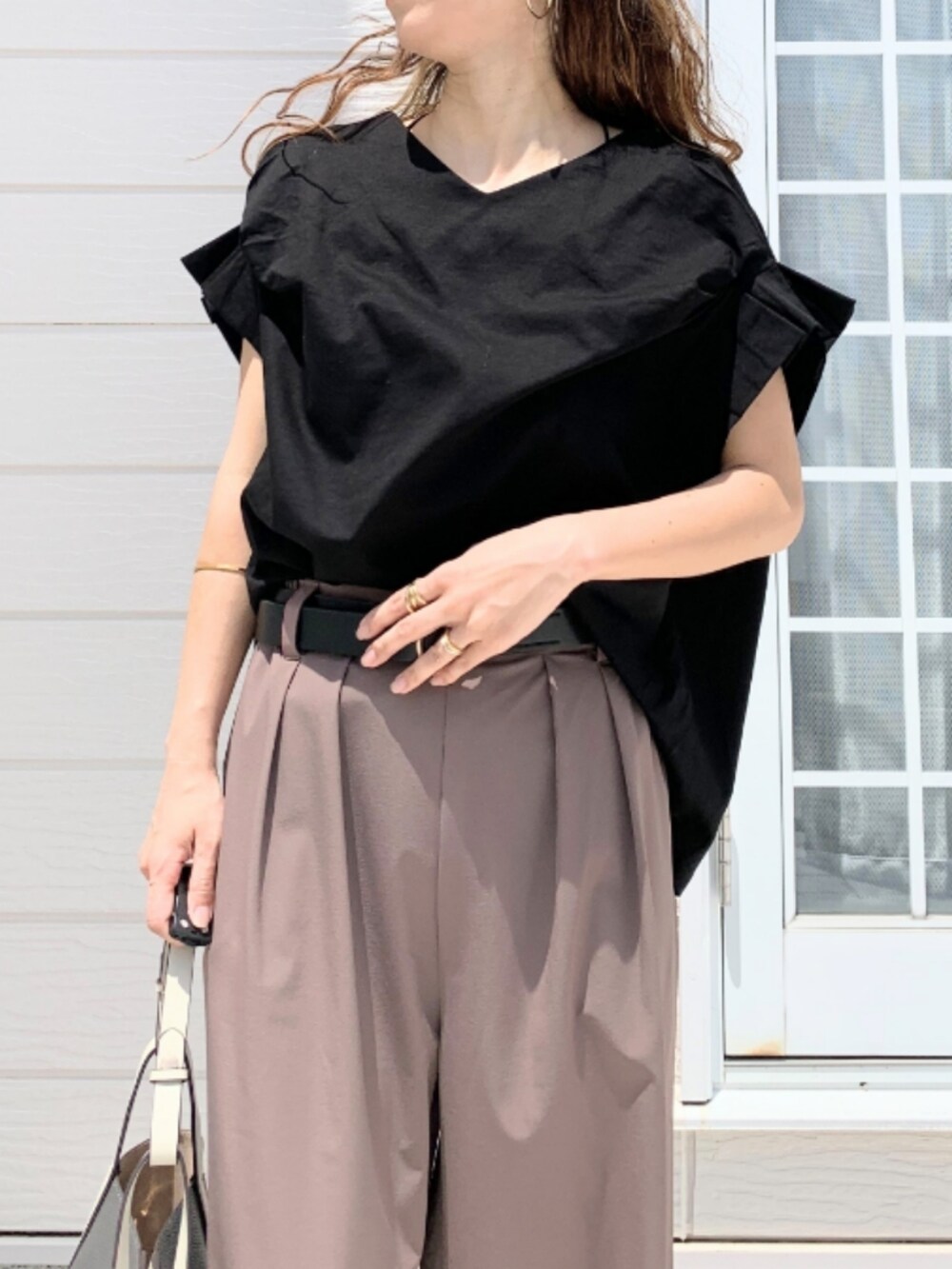 ブラウン系のその他パンツ、グレー系のトートバッグ、ブラック系のTシャツ/カットソーを着用したレディースの春コーディネートの4枚目の写真