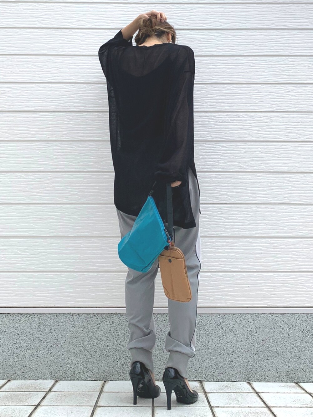 ブラック系のニット/セーター、グリーン系のショルダーバッグ、グレー系のその他パンツを着用したレディースの春コーディネートの3枚目の写真