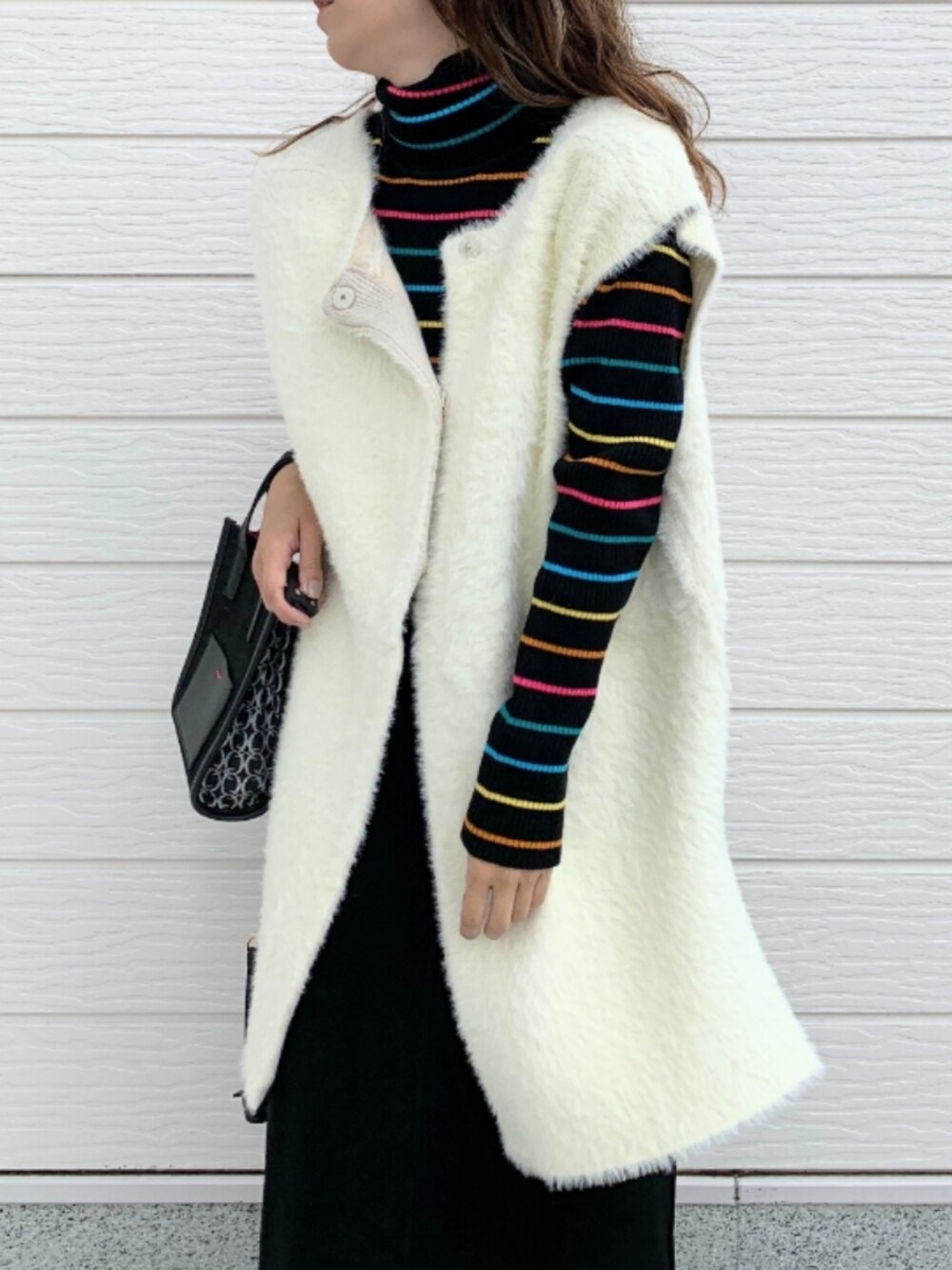 ホワイト系のスニーカー、ブラック系のニット/セーター、ブラック系のショルダーバッグを着用したレディースの秋コーディネートの4枚目の写真