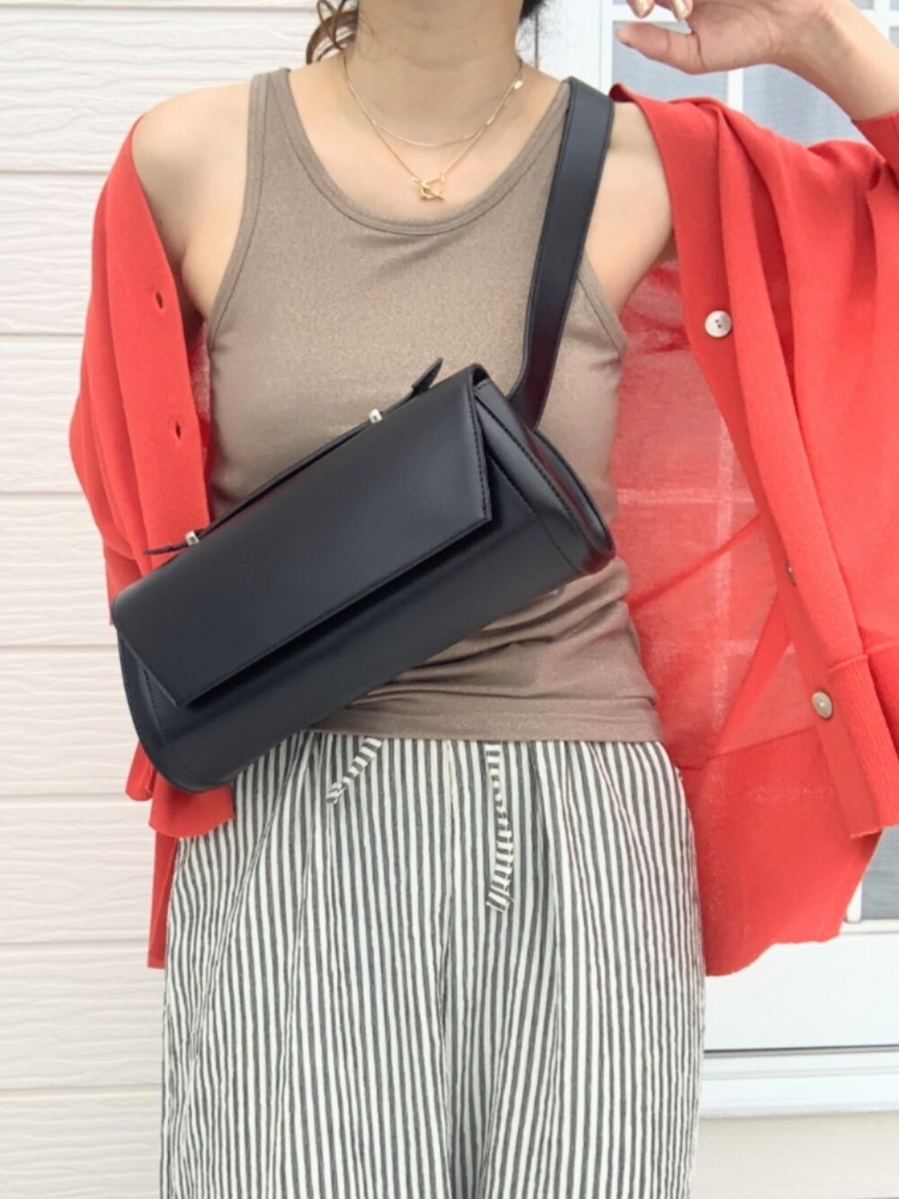 ホワイト系のスニーカー、レッド系のカーディガン/ボレロ、ベージュ系のタンクトップを着用したレディースの夏コーディネートの5枚目の写真