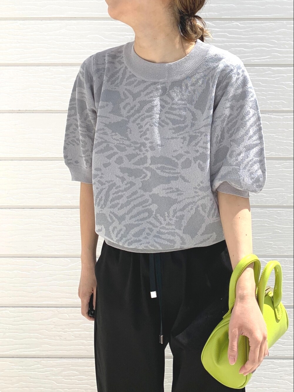 ブラック系のその他パンツ、グリーン系のショルダーバッグ、グレー系のニット/セーターを着用したレディースの春コーディネートの4枚目の写真