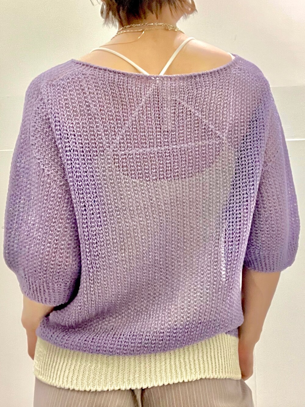 パープル系のニット/セーター、グレー系のスラックス、ブラック系のボストンバッグを着用したレディースの夏コーディネートの3枚目の写真