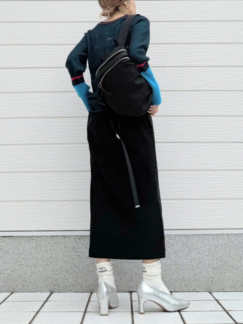 ブラック系のスカート、ブラック系のバックパック/リュック、ブラック系のニット/セーターを着用したレディースの秋コーディネートの3枚目の写真