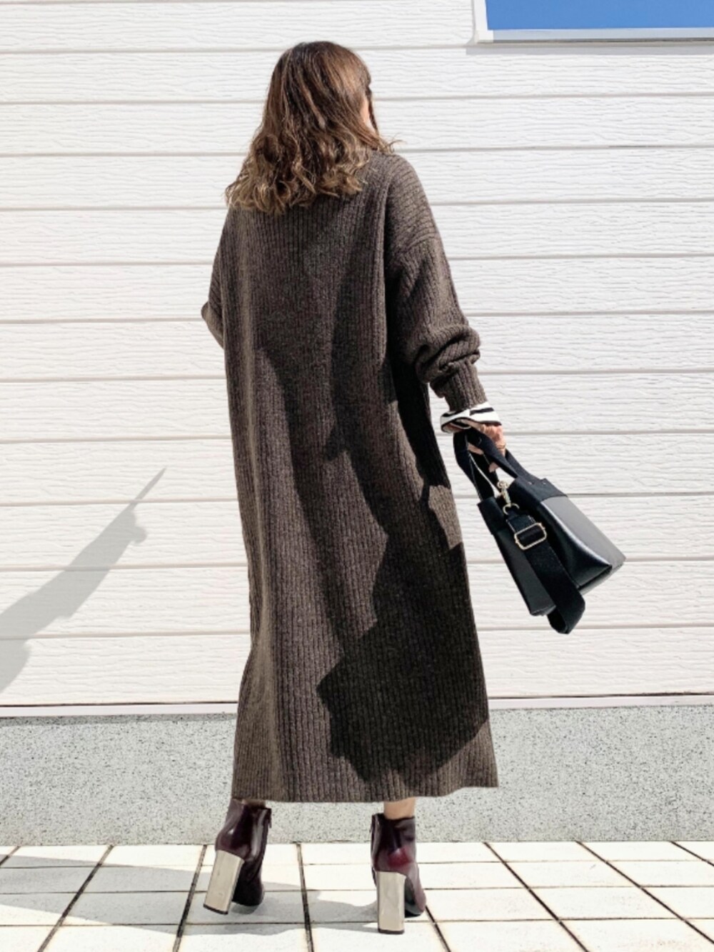 ブラウン系のブーツ、ブラック系のトートバッグ、ホワイト系のTシャツ/カットソーを着用したレディースの秋コーディネートの4枚目の写真