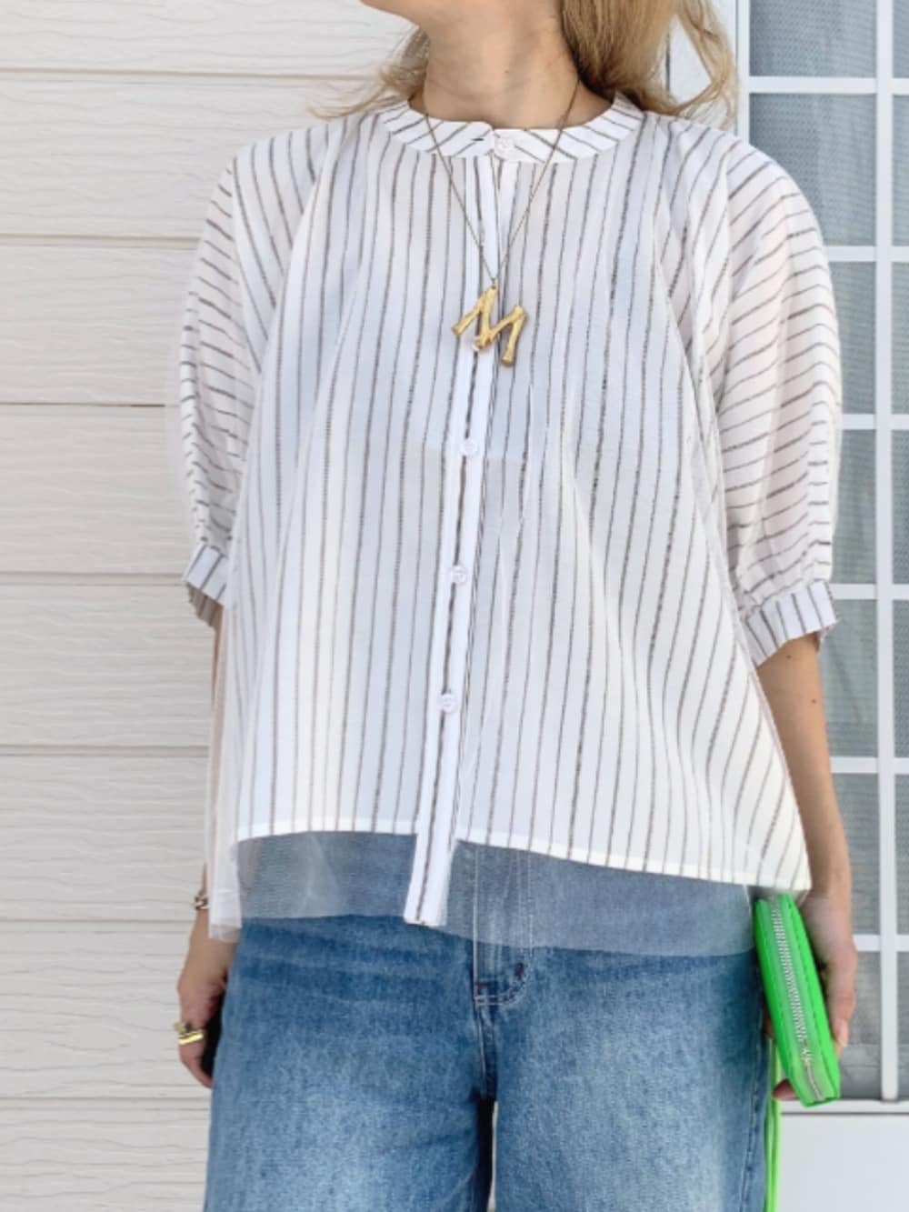 ブルー系のデニムパンツ、ホワイト系のシャツ/ブラウス、グリーン系のカードケースを着用したレディースの春コーディネートの2枚目の写真