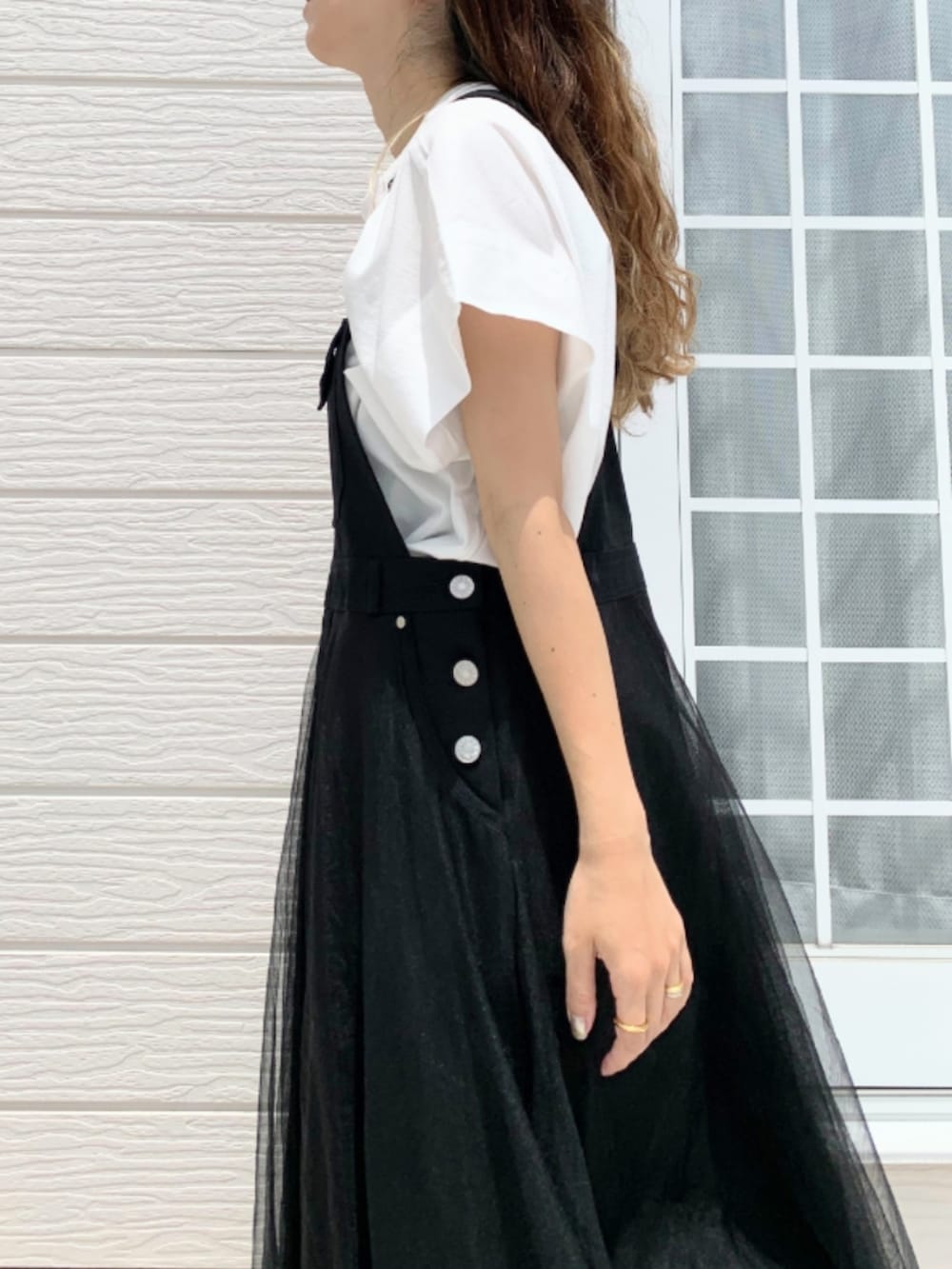 ホワイト系のスニーカー、ブラック系のジャンパースカート、ホワイト系のTシャツ/カットソーを着用したレディースの夏コーディネートの5枚目の写真