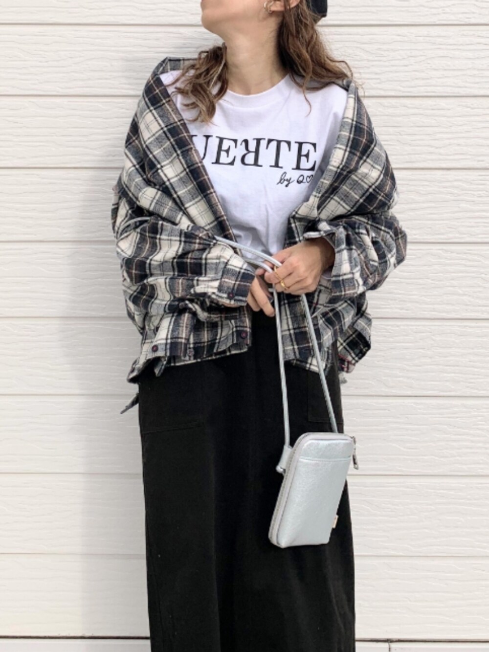 ホワイト系のTシャツ/カットソー、ブラック系のスカート、シルバー系のショルダーバッグを着用したレディースの秋コーディネートの4枚目の写真