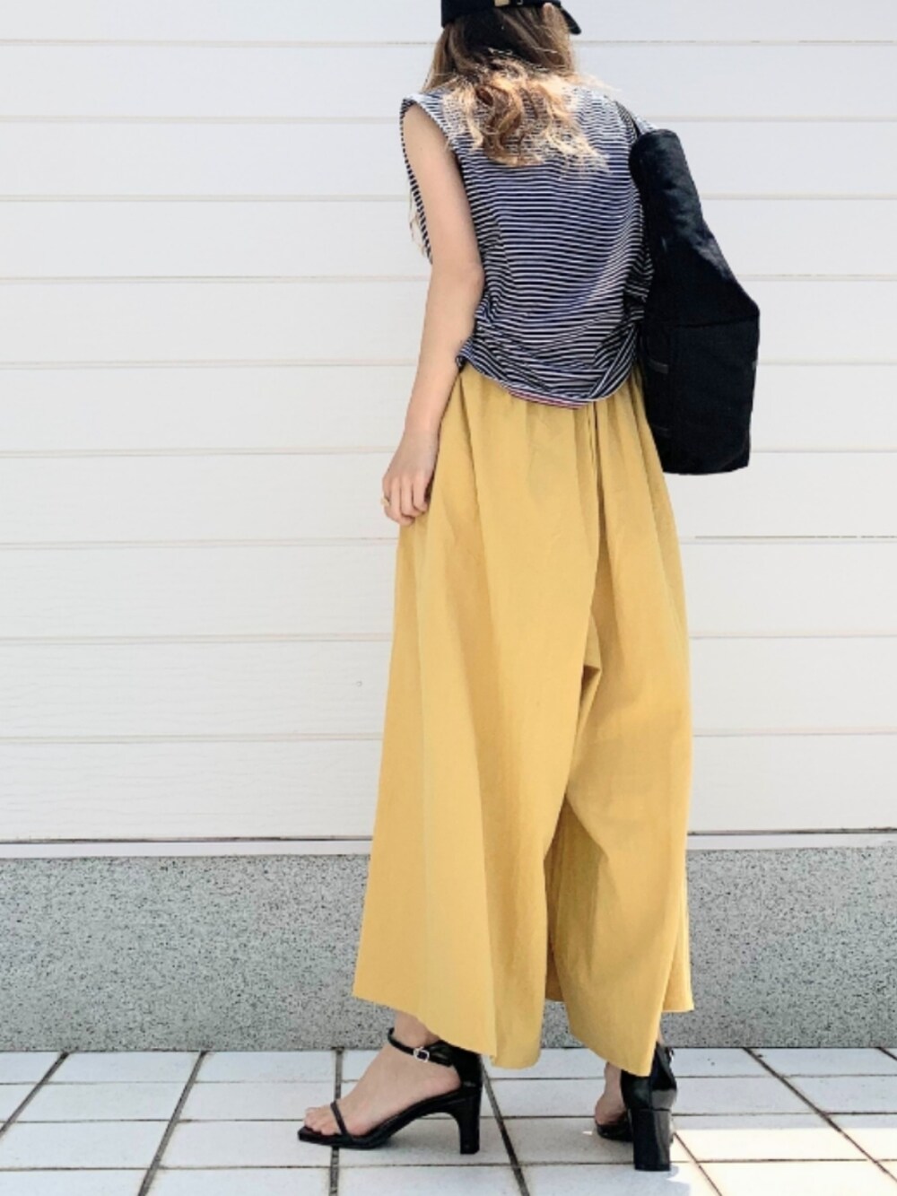 ブラック系のTシャツ/カットソー、ブラック系のトートバッグ、イエロー系のその他パンツを着用したレディースの夏コーディネートの4枚目の写真