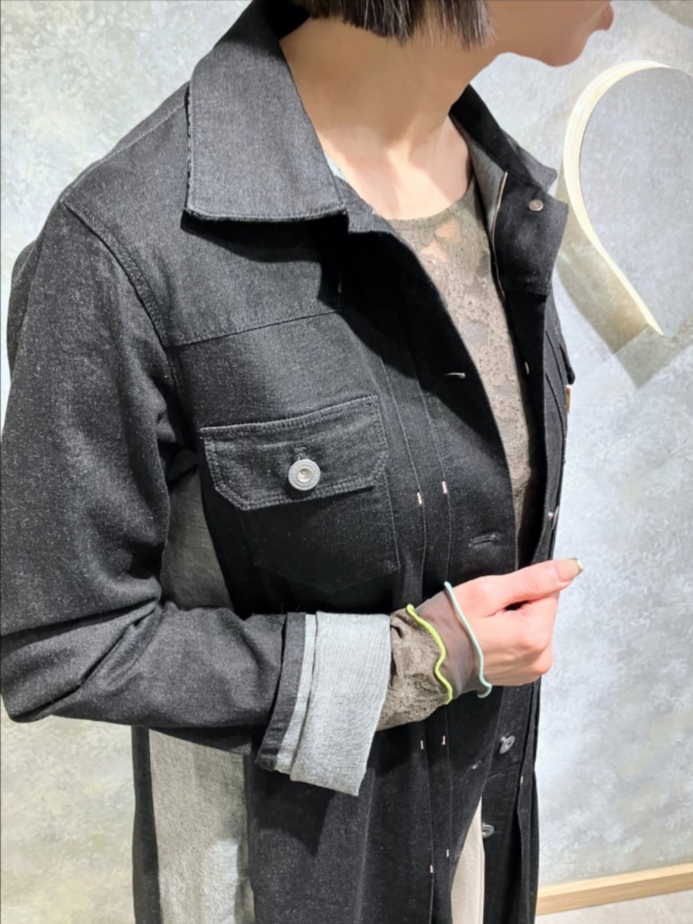 ブルー系のトートバッグ、ゴールド系のスカート、ブラック系のデニムジャケットを着用したレディースの冬コーディネートの5枚目の写真