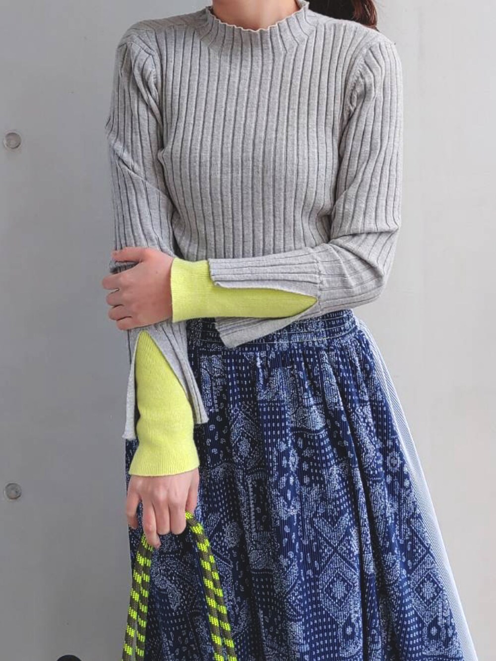 グレー系のトートバッグ、グレー系のニット/セーター、ブルー系のスカートを着用したレディースの冬コーディネートの4枚目の写真