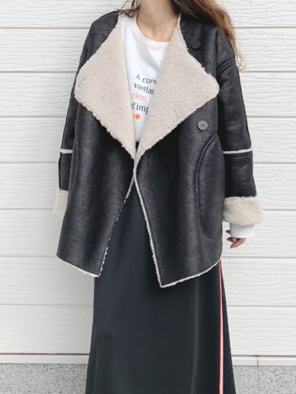 ゴールド系のスカート、ブラウン系のブーツ、ホワイト系のTシャツ/カットソーを着用したレディースの秋コーディネートの2枚目の写真