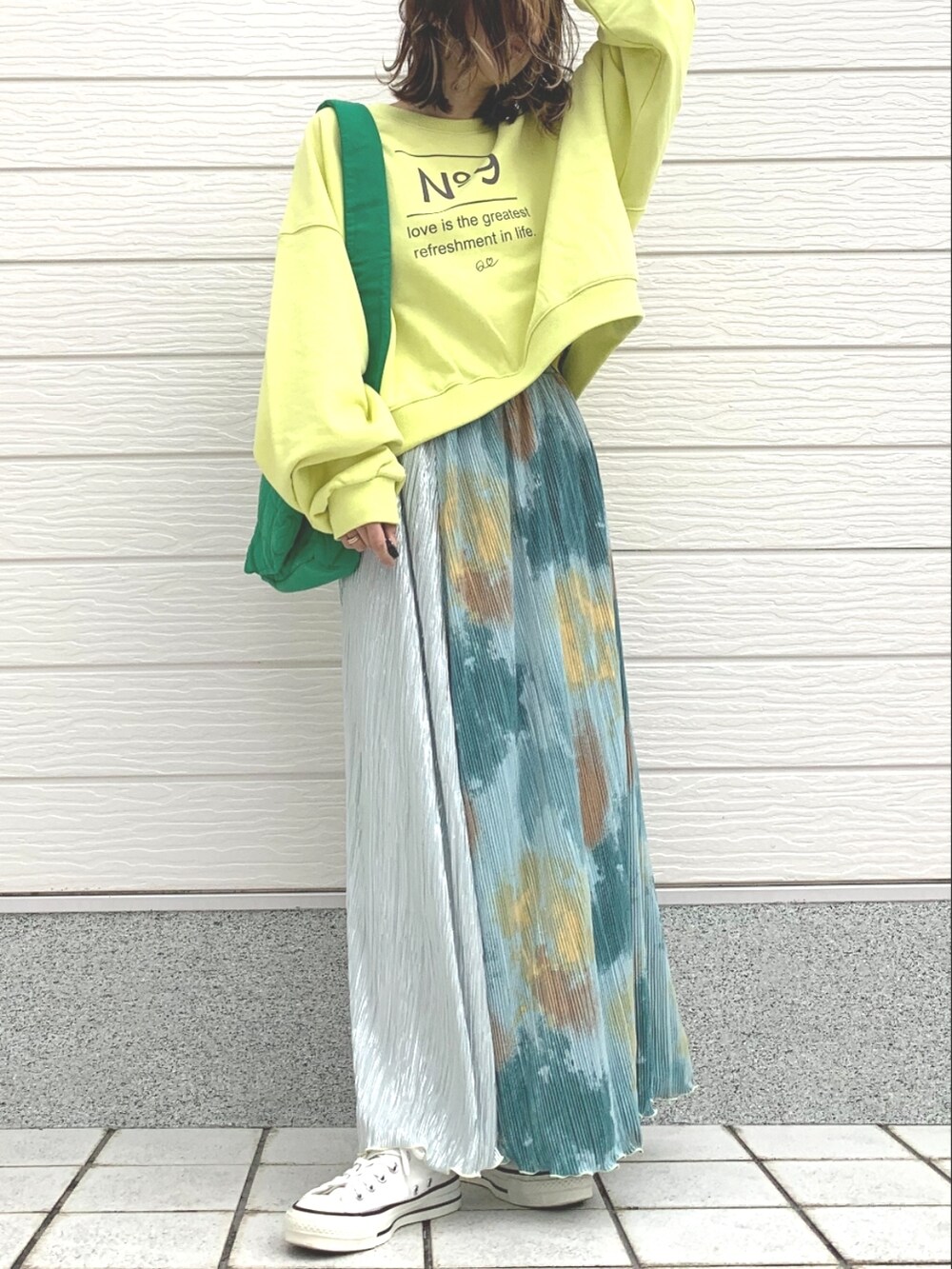 イエロー系のスウェット、ホワイト系のスニーカー、グリーン系のスカートを着用したレディースの冬コーディネートの2枚目の写真