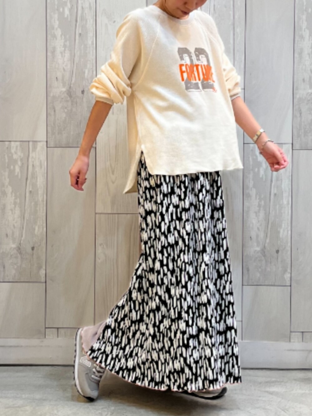ホワイト系のTシャツ/カットソー、ベージュ系のスカートを着用したレディースの秋コーディネートの2枚目の写真
