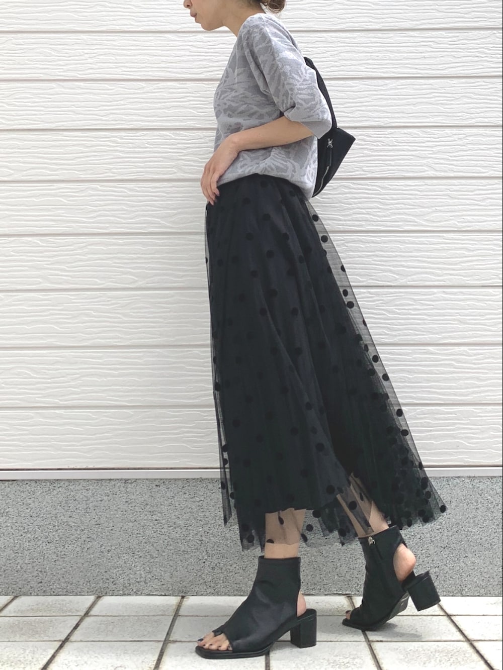 ブラック系のスカート、ブラック系のサンダル、ブラック系のショルダーバッグを着用したレディースの春コーディネートの2枚目の写真