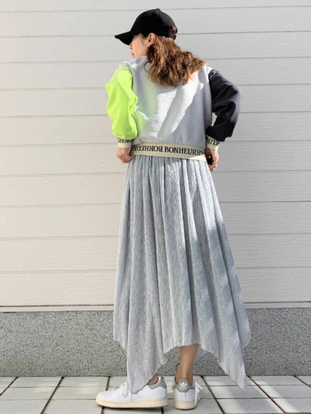 シルバー系のスカート、ホワイト系のスニーカー、グレー系のスウェットを着用したレディースの冬コーディネートの3枚目の写真