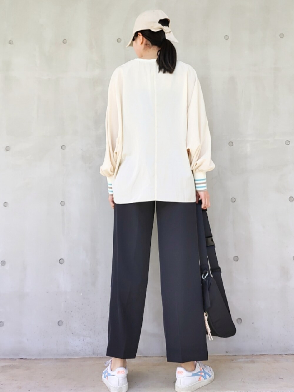 ホワイト系のスニーカー、ブラック系のスラックス、ホワイト系のシャツ/ブラウスを着用したレディースの春コーディネートの2枚目の写真