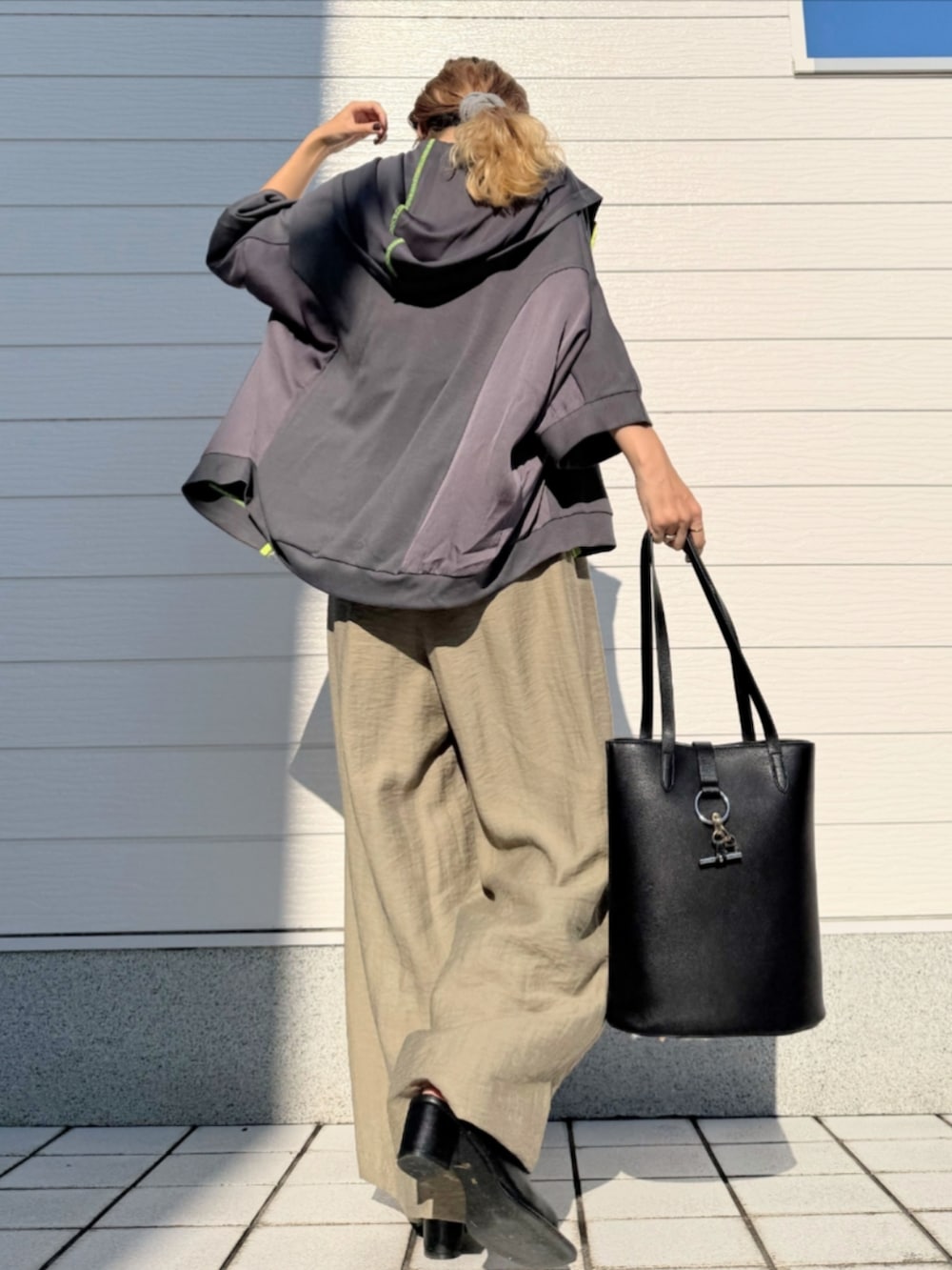 ブラック系のトートバッグ、ブラック系のタンクトップ、グリーン系のその他パンツを着用したレディースの夏コーディネートの3枚目の写真