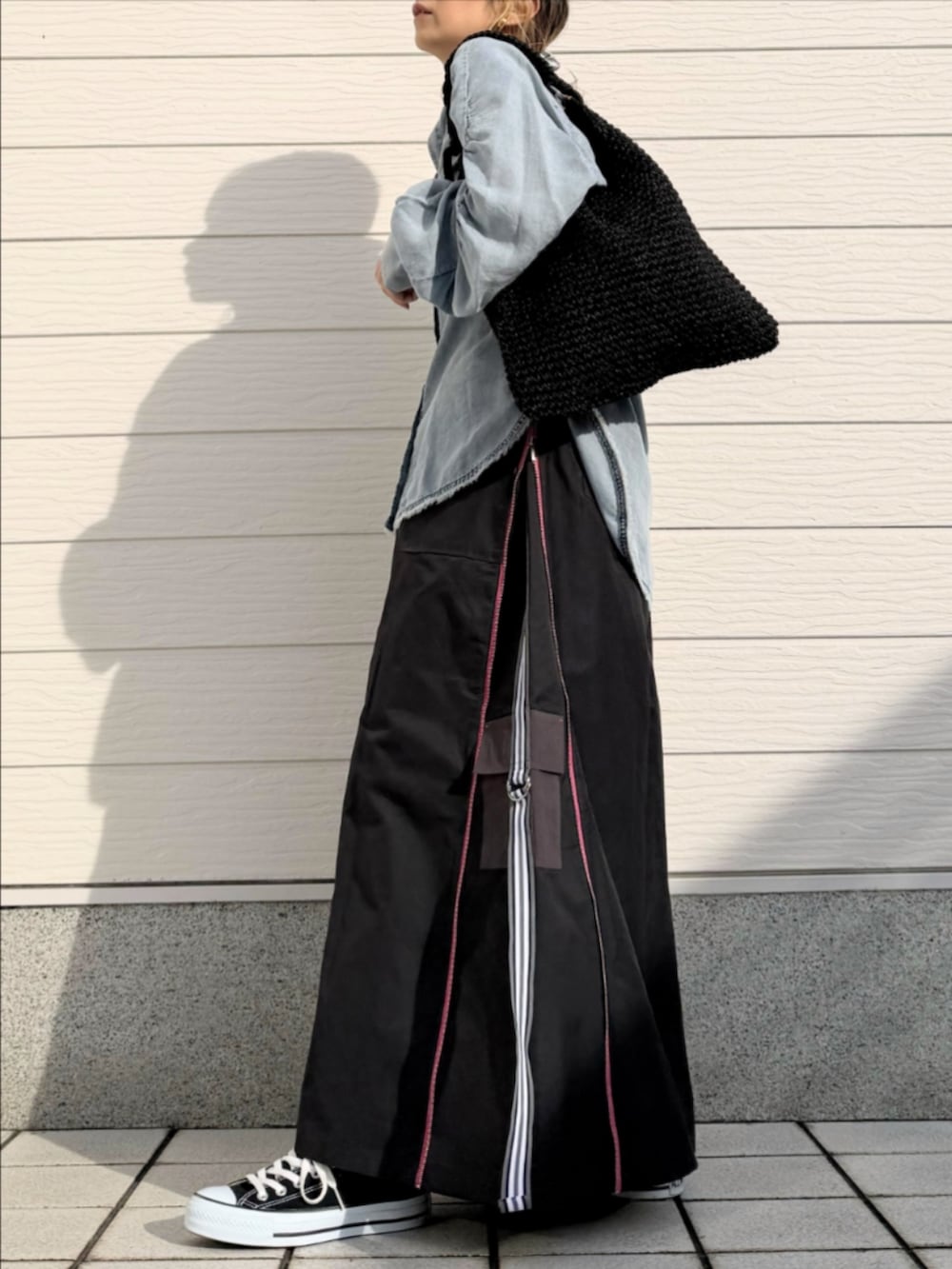 グレー系のスカート、ブラック系のスニーカー、ブルー系のシャツ/ブラウスを着用したレディースの冬コーディネートの2枚目の写真