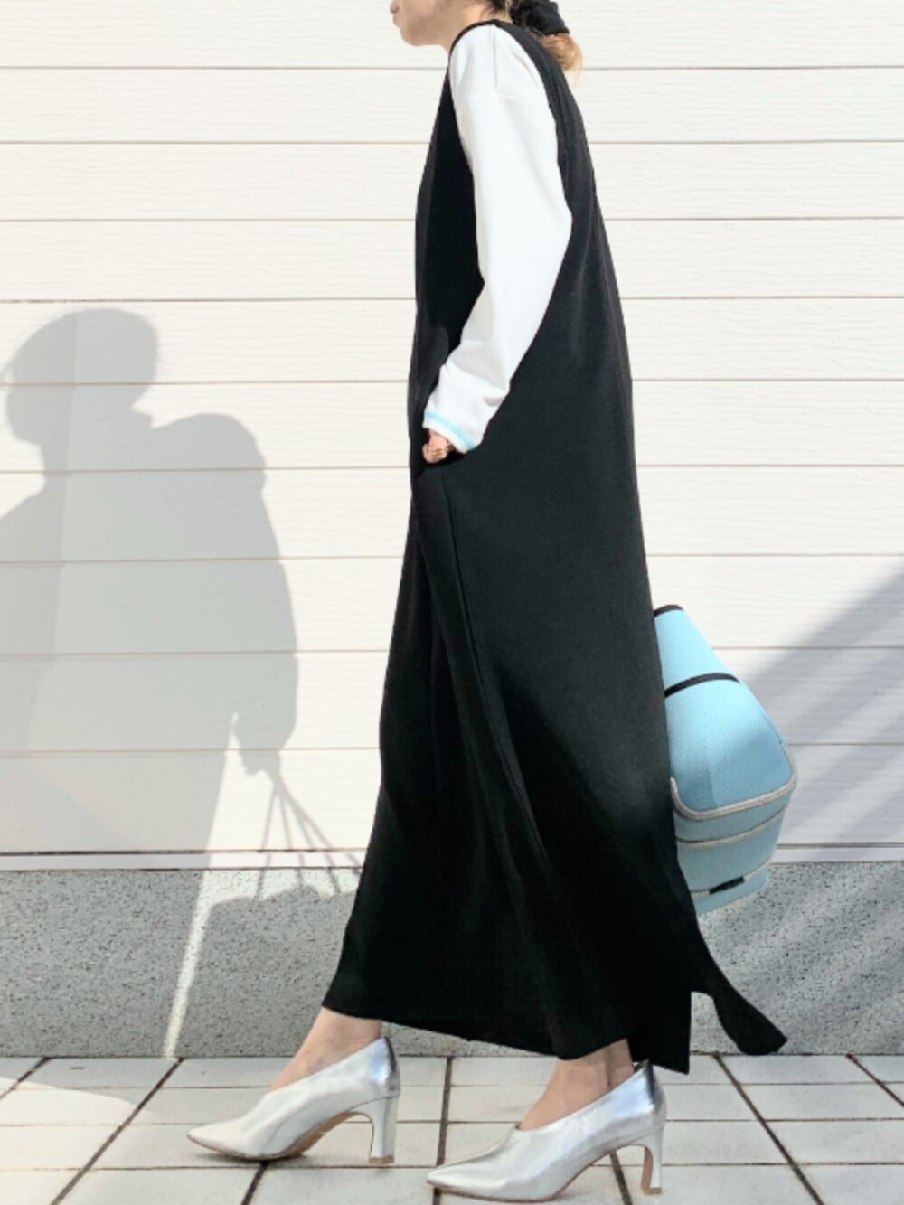 ブルー系のトートバッグ、ブラック系のワンピース、ホワイト系のTシャツ/カットソーを着用したレディースの冬コーディネートの2枚目の写真