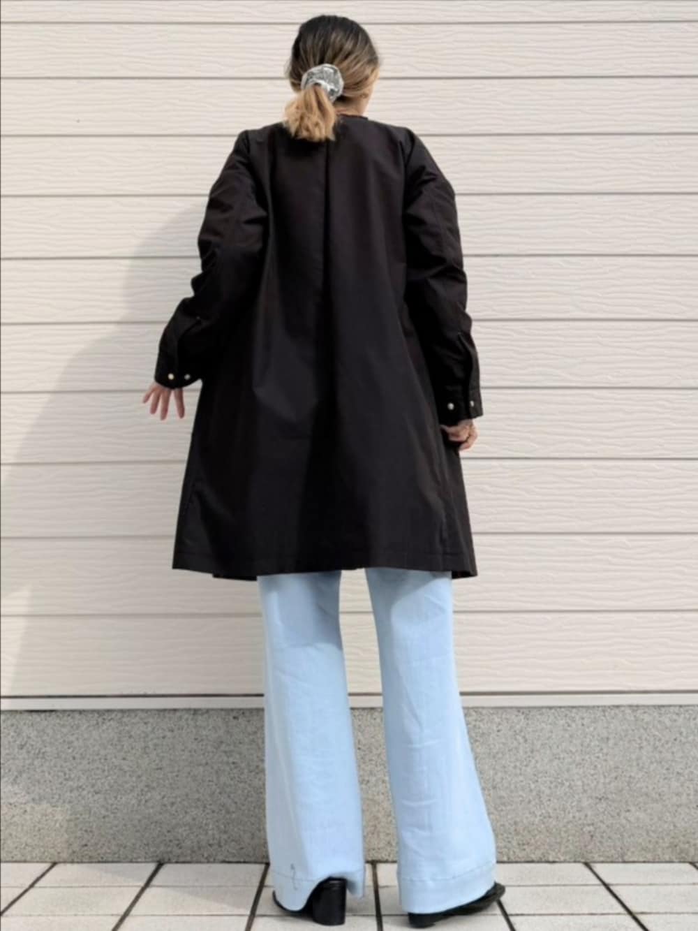 ブルー系のデニムパンツ、ブラック系のサンダル、グレー系のスウェットを着用したレディースの冬コーディネートの3枚目の写真