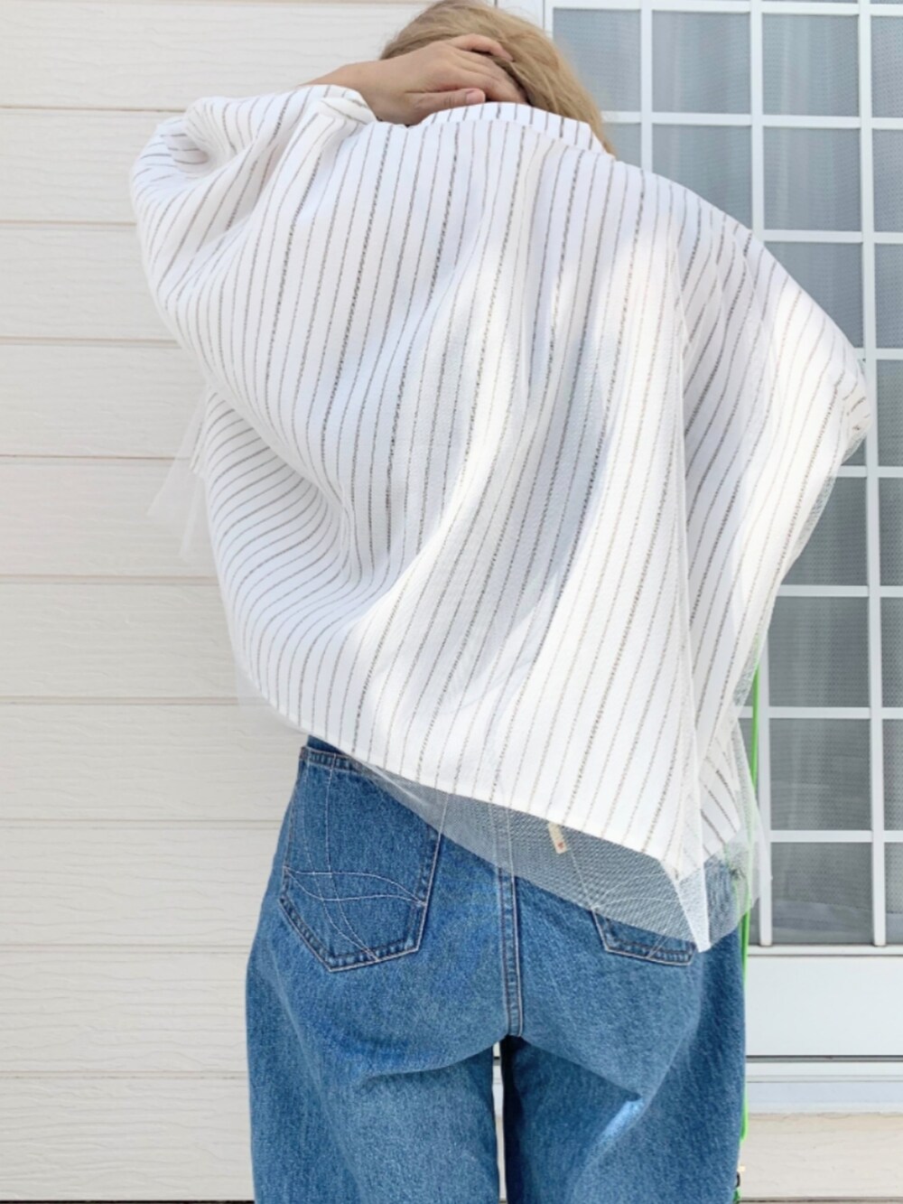 ブルー系のデニムパンツ、ホワイト系のシャツ/ブラウス、グリーン系のカードケースを着用したレディースの春コーディネートの4枚目の写真