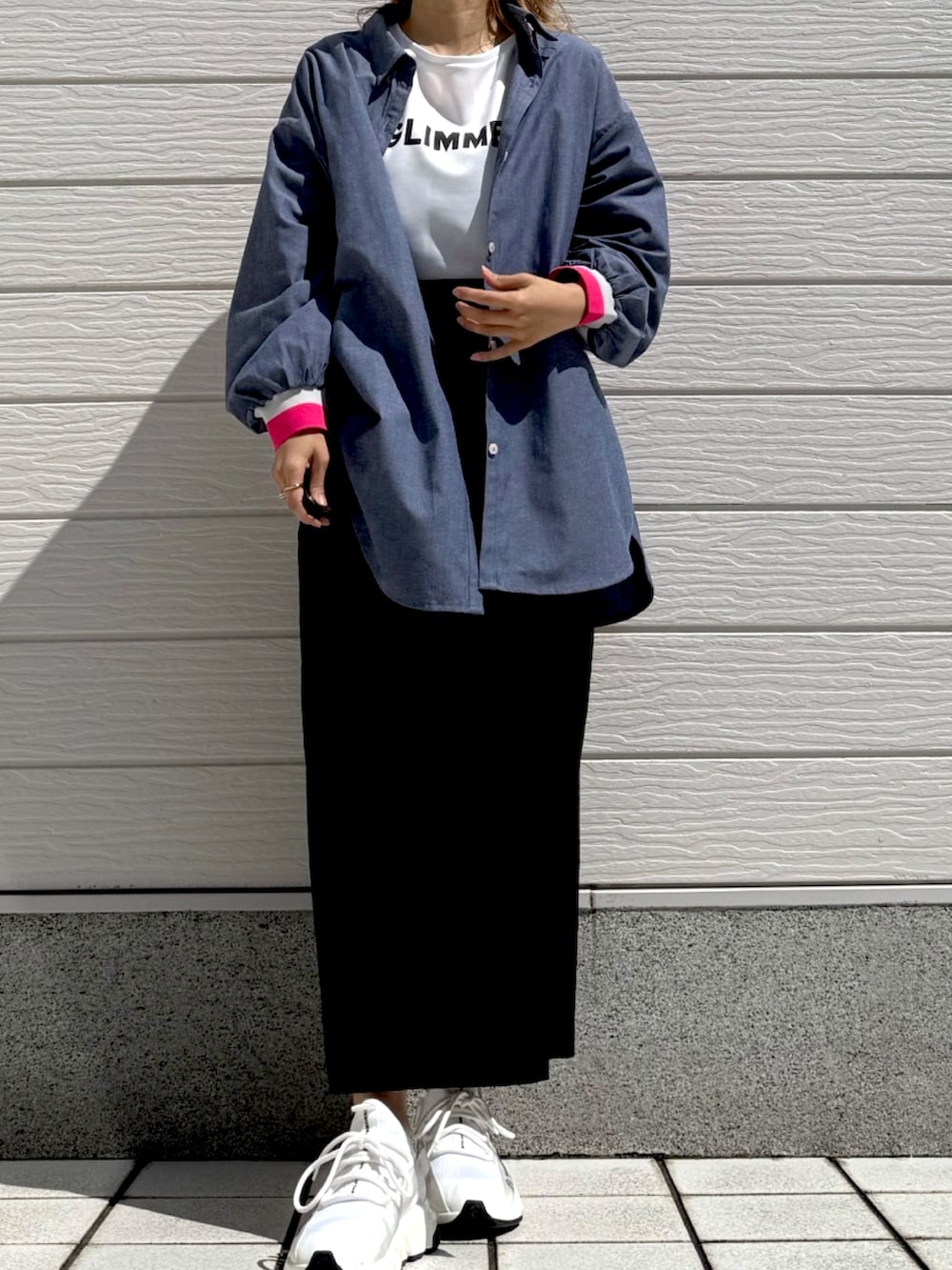ブラック系のスカート、ブルー系のシャツ/ブラウス、ホワイト系のTシャツ/カットソーを着用したレディースの春コーディネートの3枚目の写真