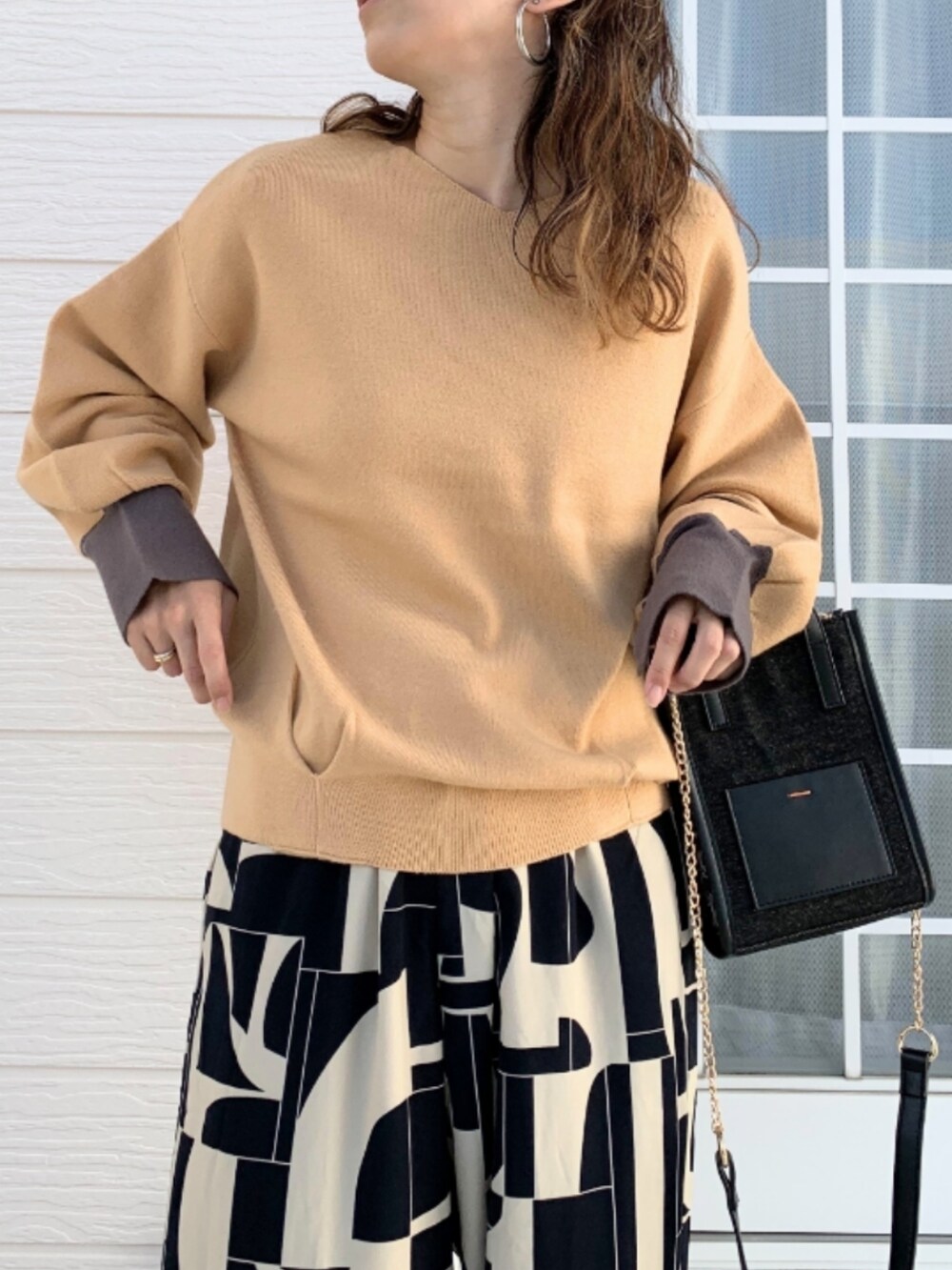 ブラウン系のショルダーバッグ、ベージュ系のその他パンツ、イエロー系のニット/セーターを着用したレディースの秋コーディネートの3枚目の写真