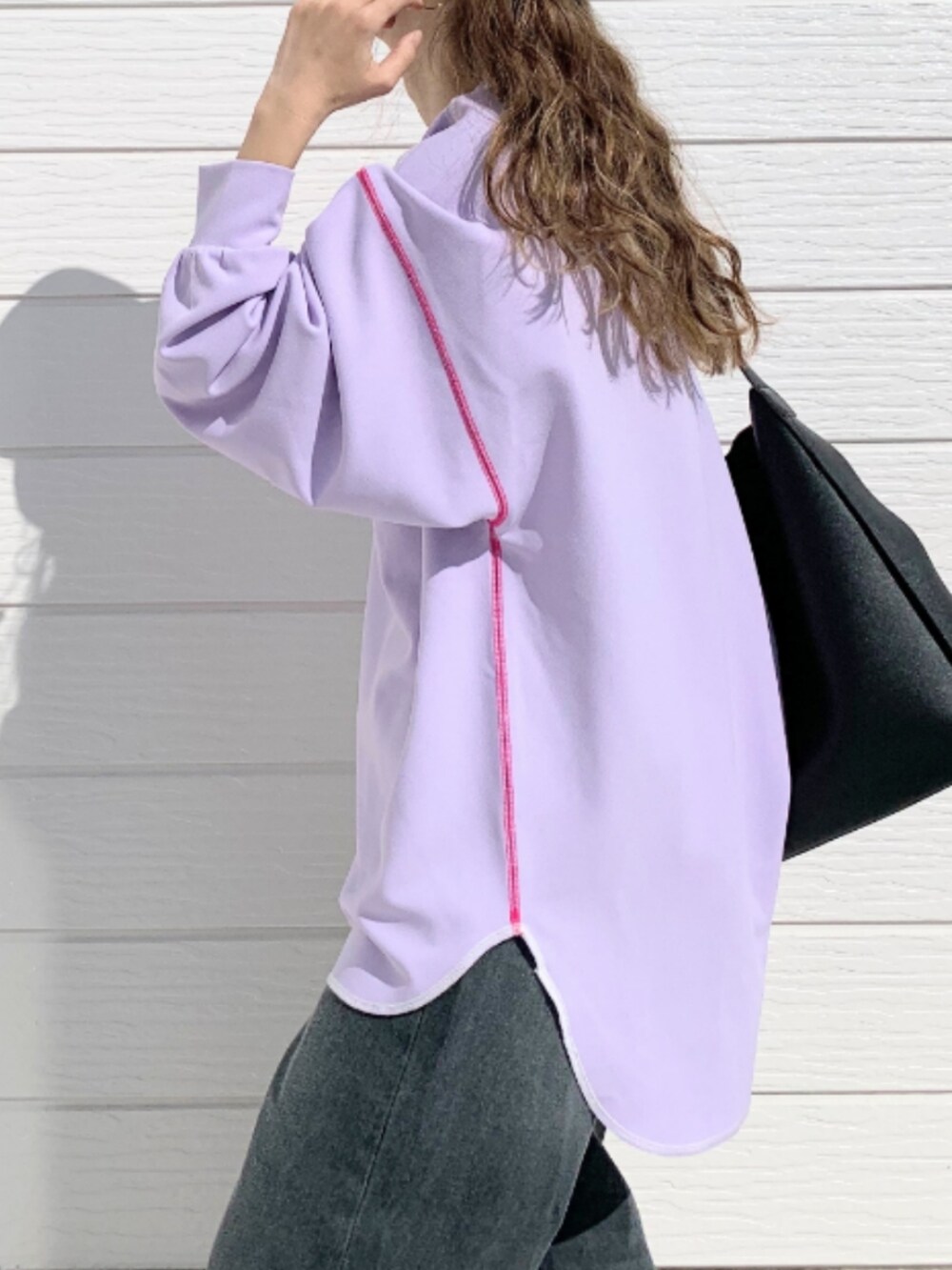 グレー系のデニムパンツ、ブラック系のトートバッグ、パープル系のTシャツ/カットソーを着用したレディースの春コーディネートの4枚目の写真