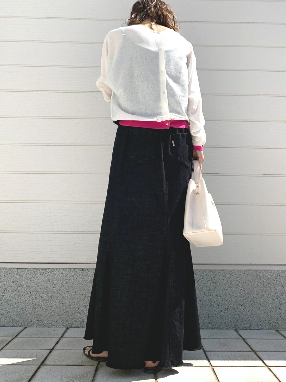 ホワイト系のハンドバッグ、ブラック系のデニムスカート、ホワイト系のカーディガン/ボレロを着用したレディースの春コーディネートの2枚目の写真