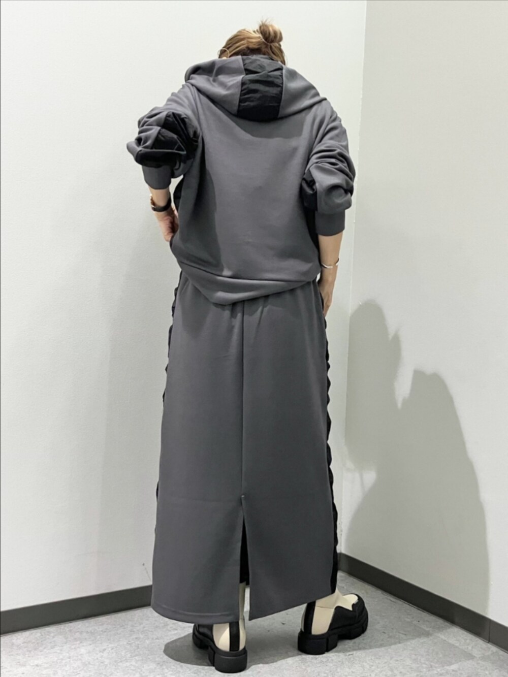 グレー系のスカート、グレー系のパーカー、ホワイト系のブーツを着用したレディースの秋コーディネートの3枚目の写真