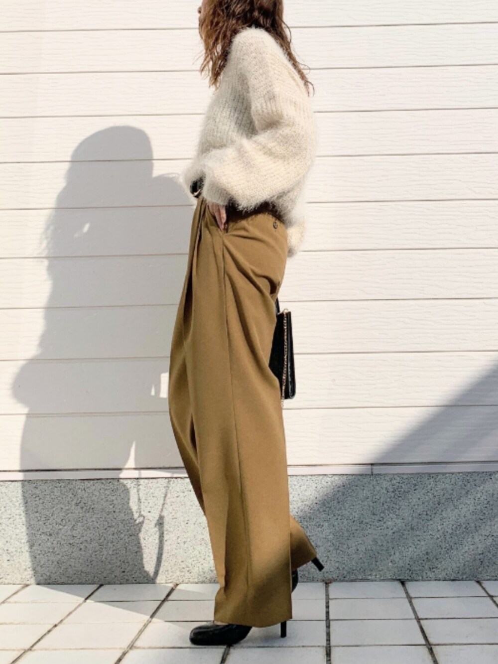 ブラック系のショルダーバッグ、イエロー系のその他パンツ、ホワイト系のニット/セーターを着用したレディースの秋コーディネートの2枚目の写真