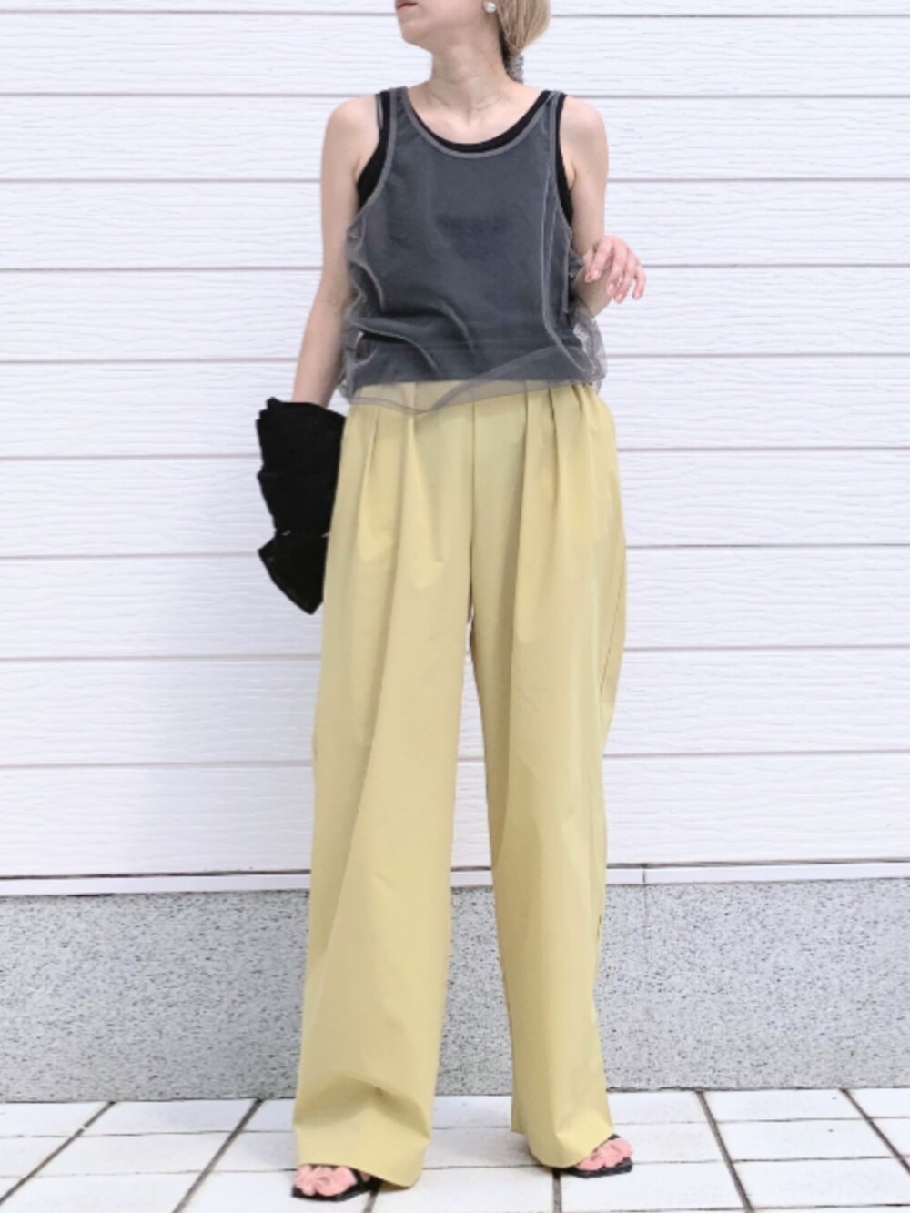 イエロー系のその他パンツ、ブラック系のタンクトップ、ブラック系のカーディガン/ボレロを着用したレディースの春コーディネートの2枚目の写真