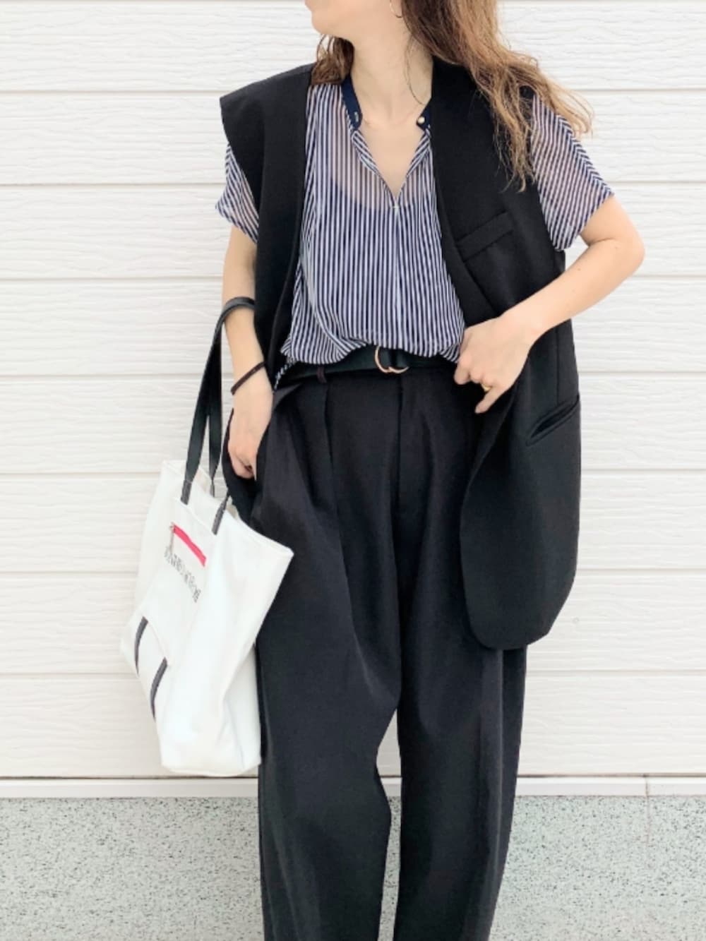 ブラック系のその他パンツ、ホワイト系のトートバッグ、ブルー系のシャツ/ブラウスを着用したレディースの春コーディネートの4枚目の写真