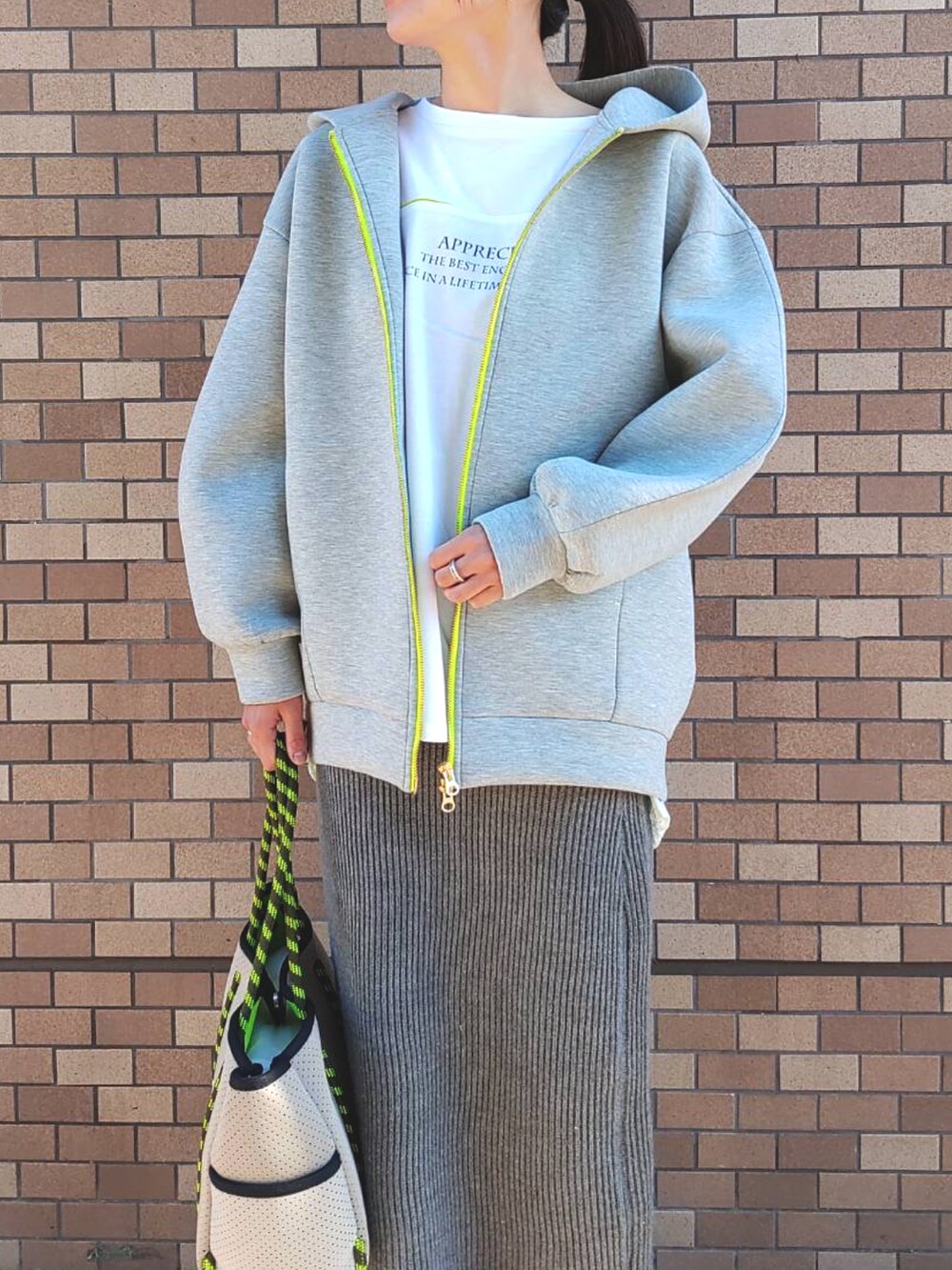 ホワイト系のスニーカー、グレー系のトートバッグ、グレー系のその他アウターを着用したレディースの冬コーディネートの3枚目の写真