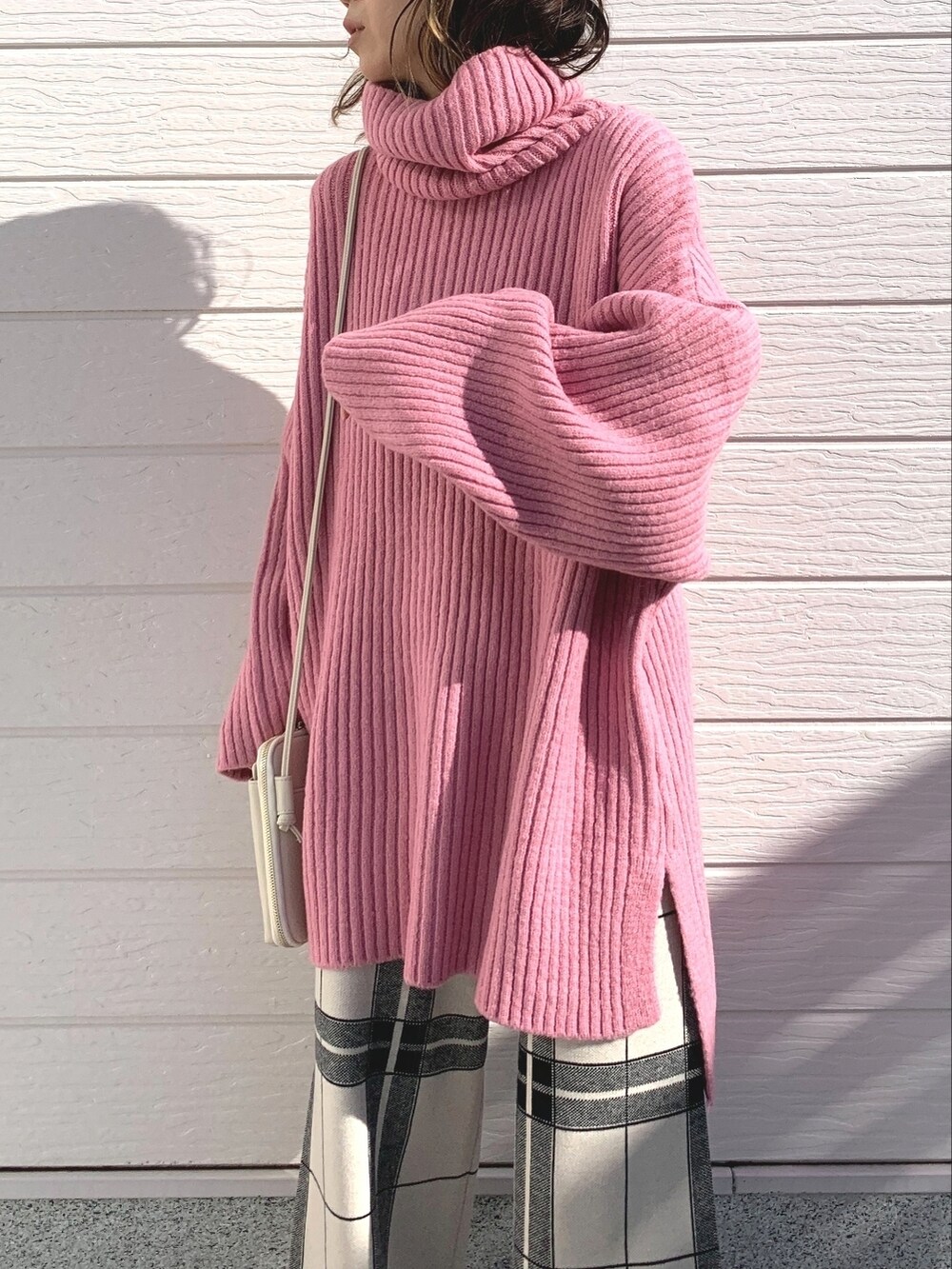 ホワイト系のショルダーバッグ、ホワイト系のその他パンツ、ピンク系のニット/セーターを着用したレディースの冬コーディネートの4枚目の写真