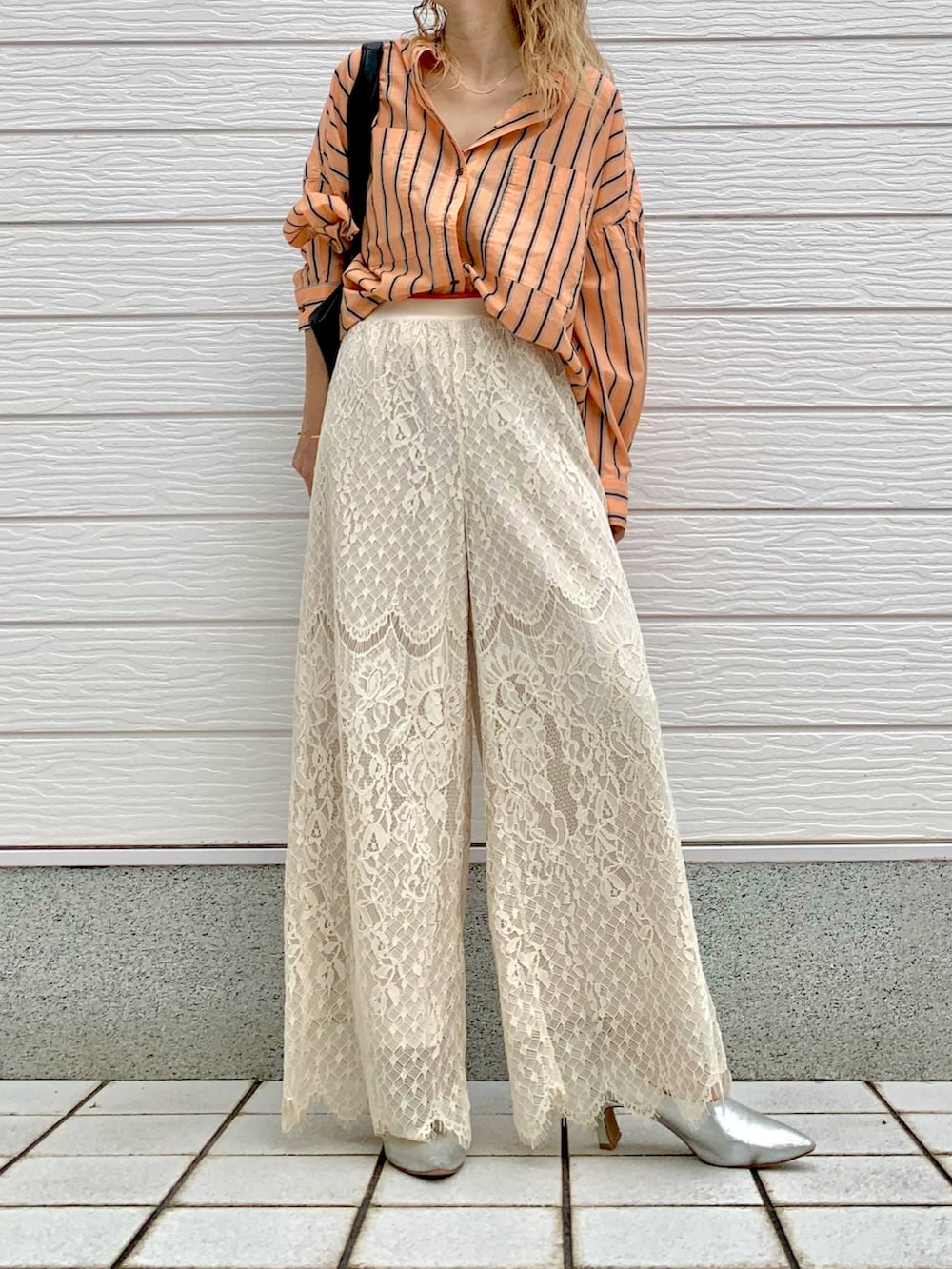 オレンジ系のシャツ/ブラウス、ホワイト系のその他パンツ、ブラック系のトートバッグを着用したレディースの夏コーディネートの2枚目の写真