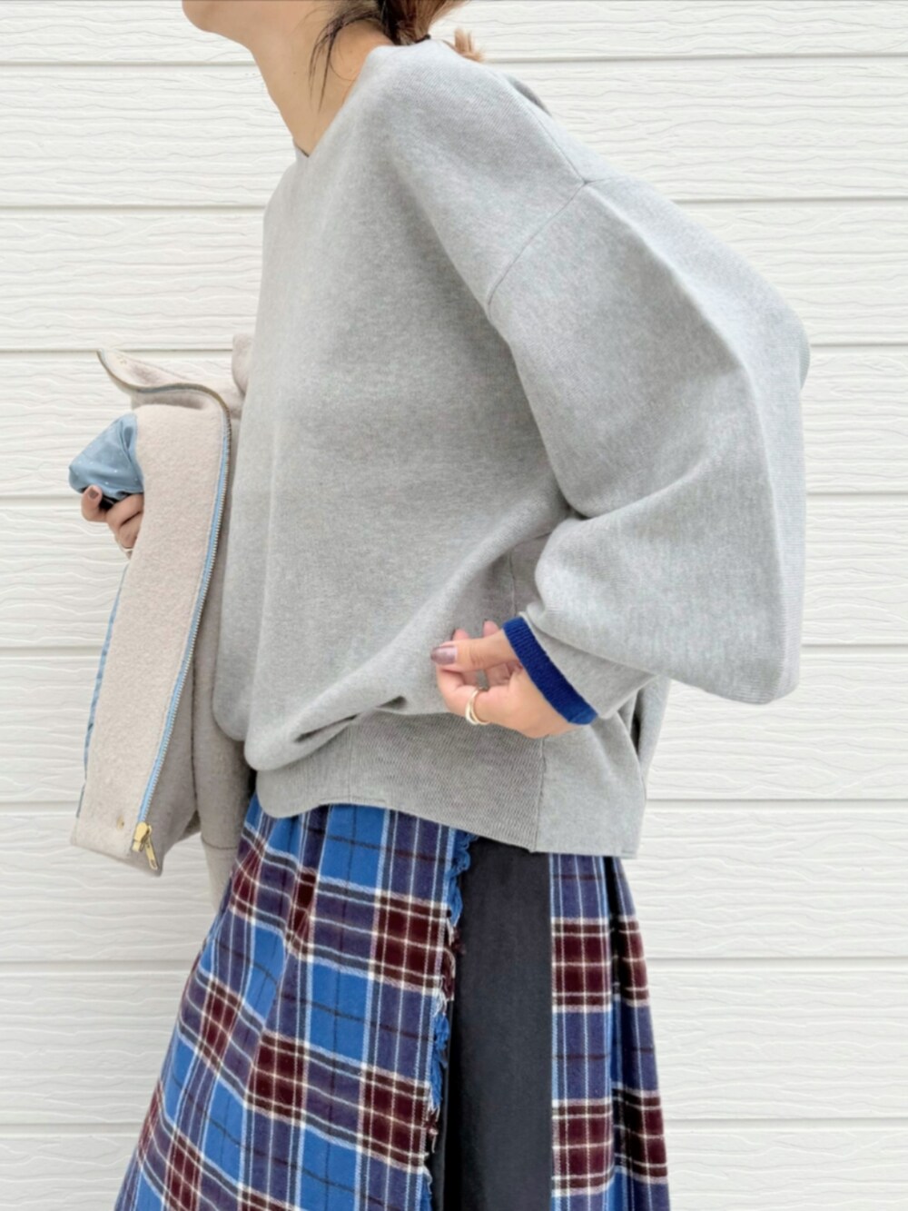 ブルー系のスカート、ブラック系のブーツ、ベージュ系のその他アウターを着用したレディースの秋コーディネートの5枚目の写真