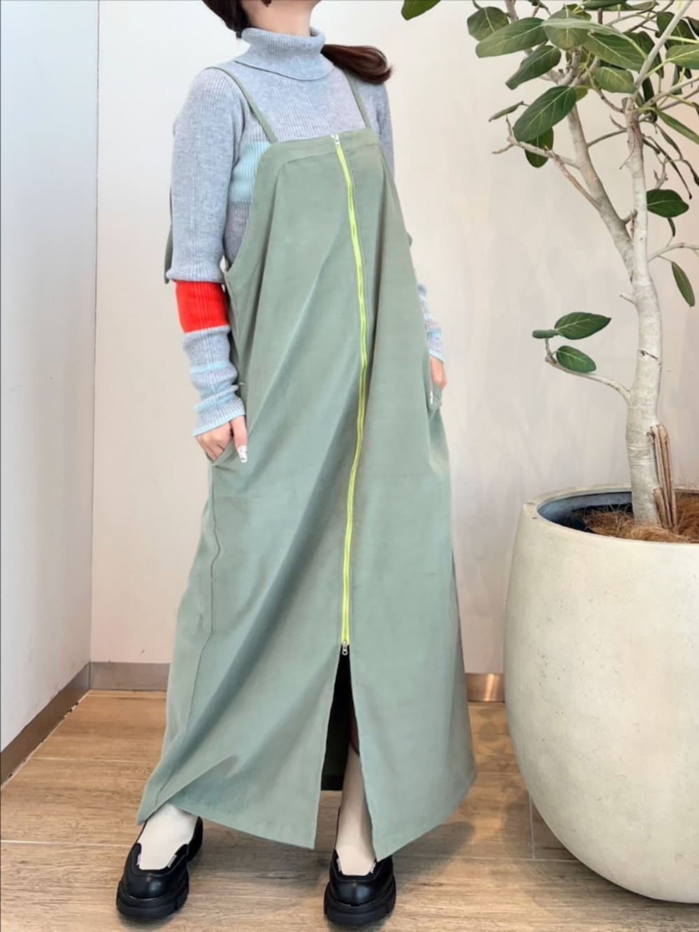 ホワイト系のブーツ、グリーン系のワンピース、グレー系のニット/セーターを着用したレディースの冬コーディネートの2枚目の写真