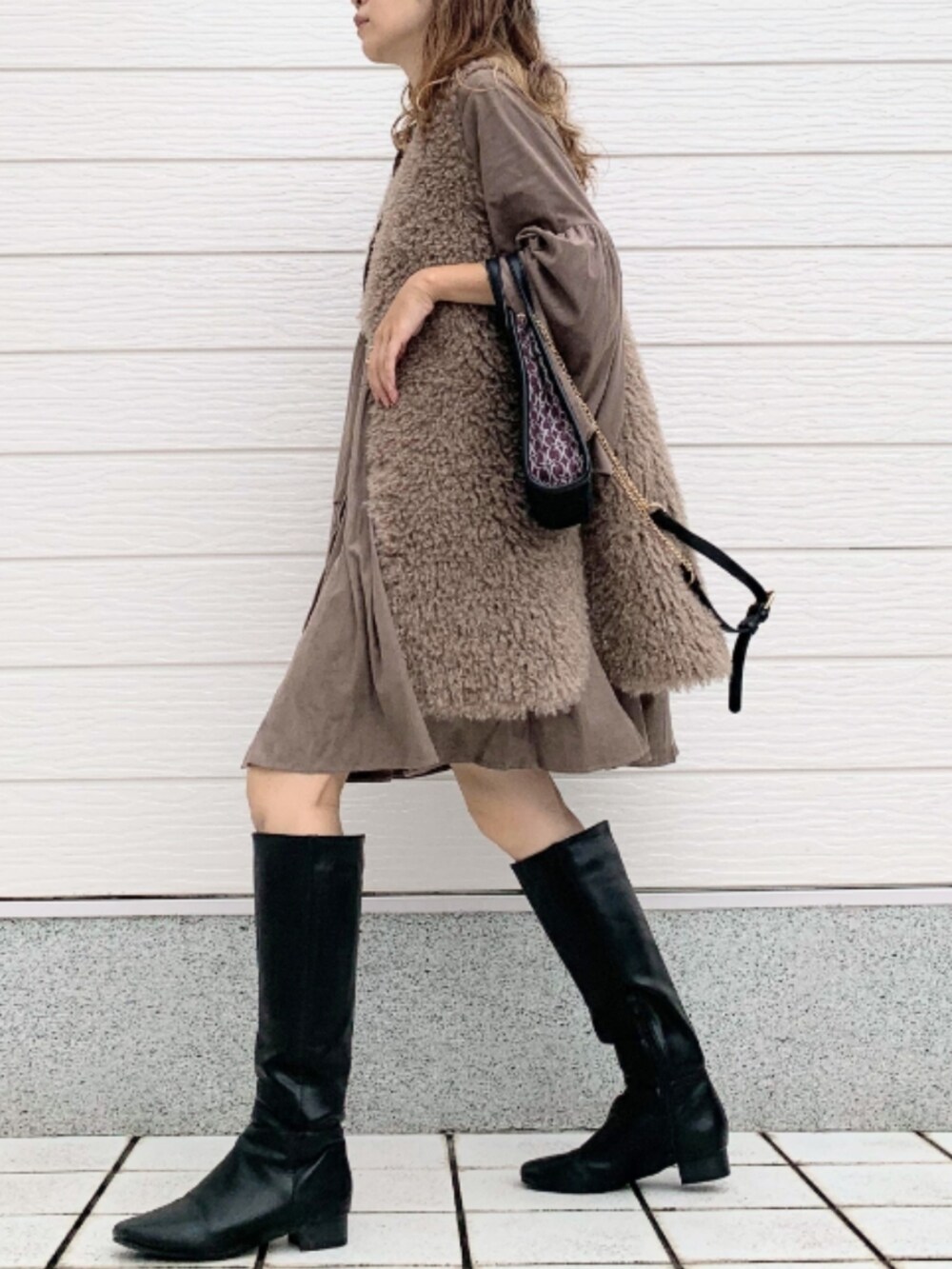 ブラック系のブーツ、ブラウン系のシャツ/ブラウス、ブラウン系のベストを着用したレディースの秋コーディネートの3枚目の写真