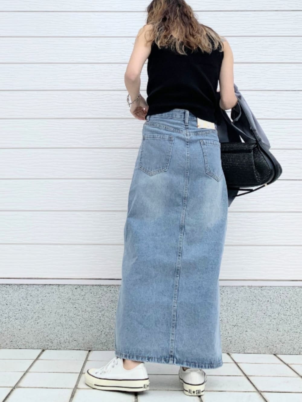 ブルー系のデニムスカート、ホワイト系のスニーカー、グレー系のテーラードジャケットを着用したレディースの春コーディネートの2枚目の写真