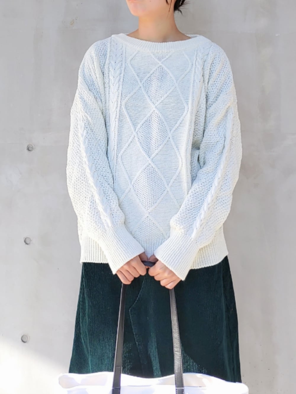 ホワイト系のトートバッグ、ブラック系のスニーカー、ホワイト系のニット/セーターを着用したレディースの冬コーディネートの4枚目の写真