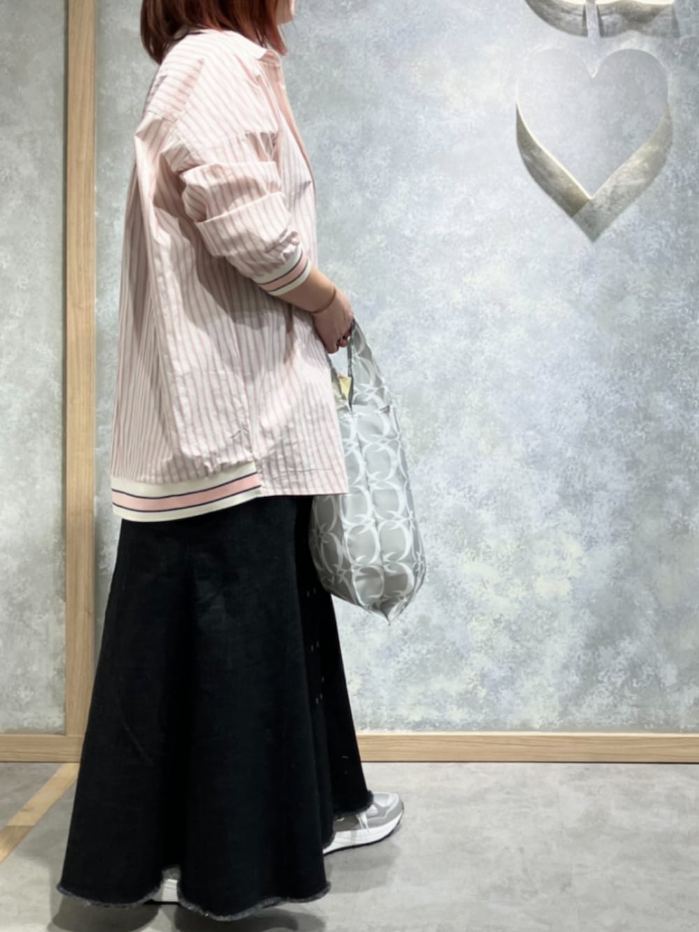 ブルー系のデニムスカート、シルバー系のスニーカー、グレー系のエコバッグ/サブバッグを着用したレディースの冬コーディネートの2枚目の写真