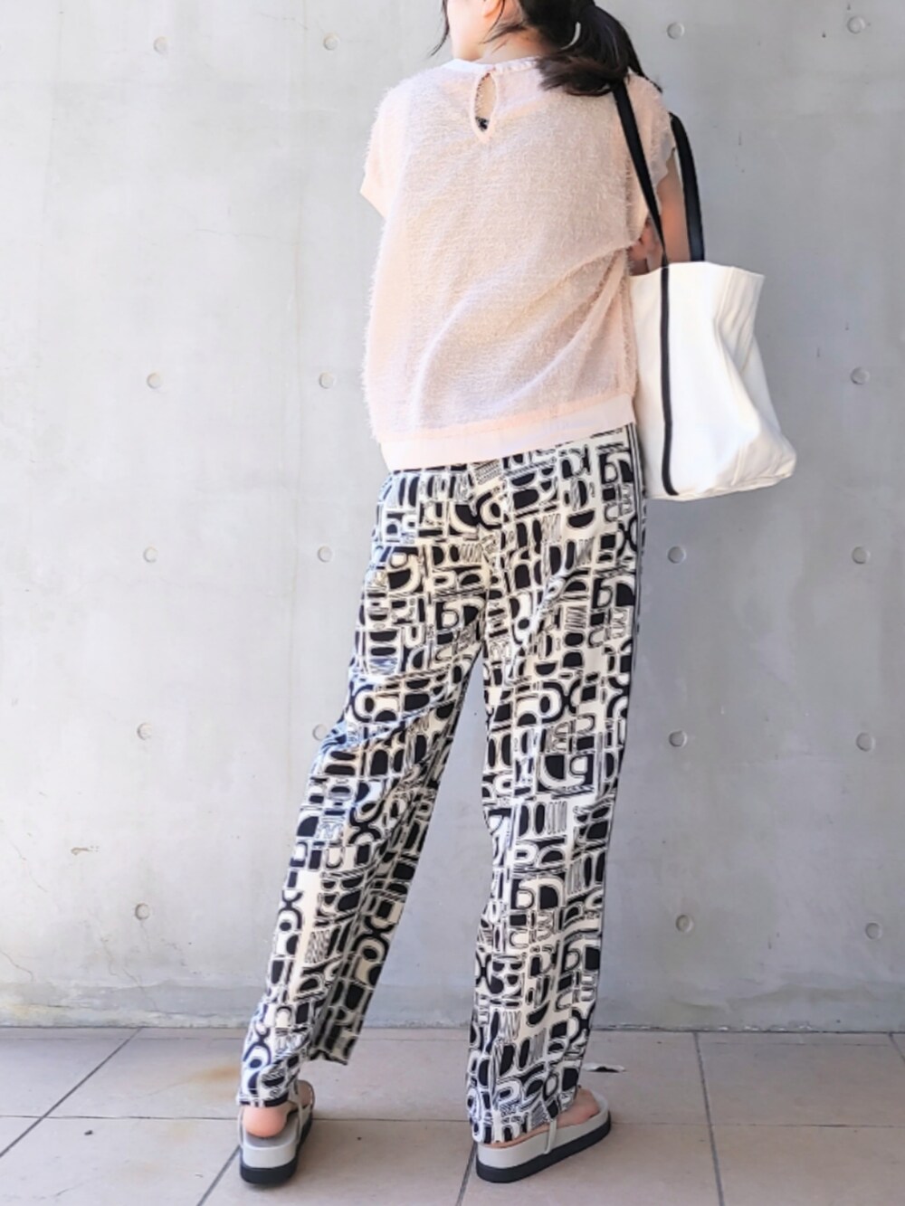 グレー系のサンダル、ホワイト系のトートバッグ、ピンク系のTシャツ/カットソーを着用したレディースの春コーディネートの2枚目の写真