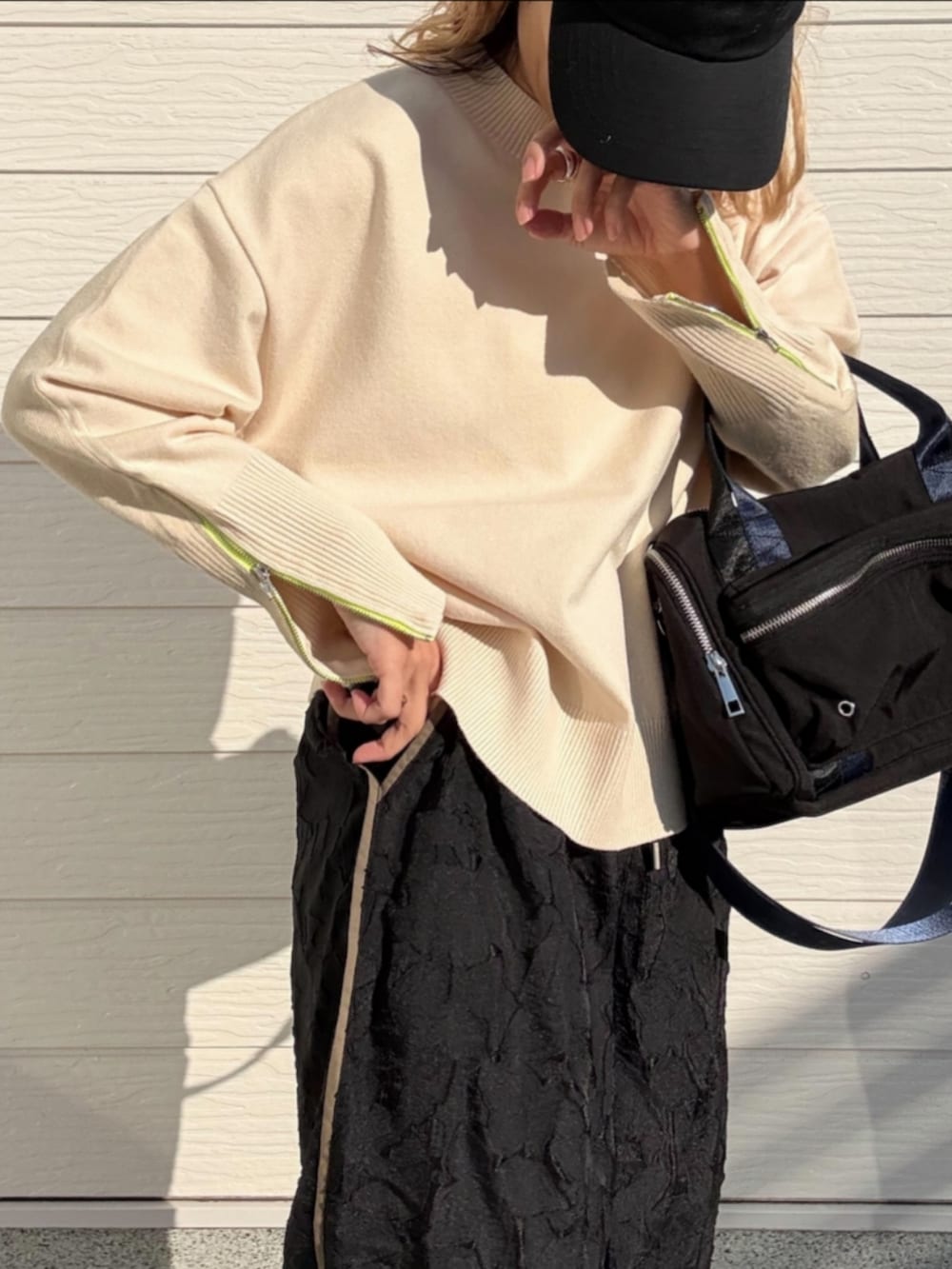 ホワイト系のニット/セーター、ブラック系のボストンバッグ、ブラック系のその他パンツを着用したレディースの冬コーディネートの5枚目の写真