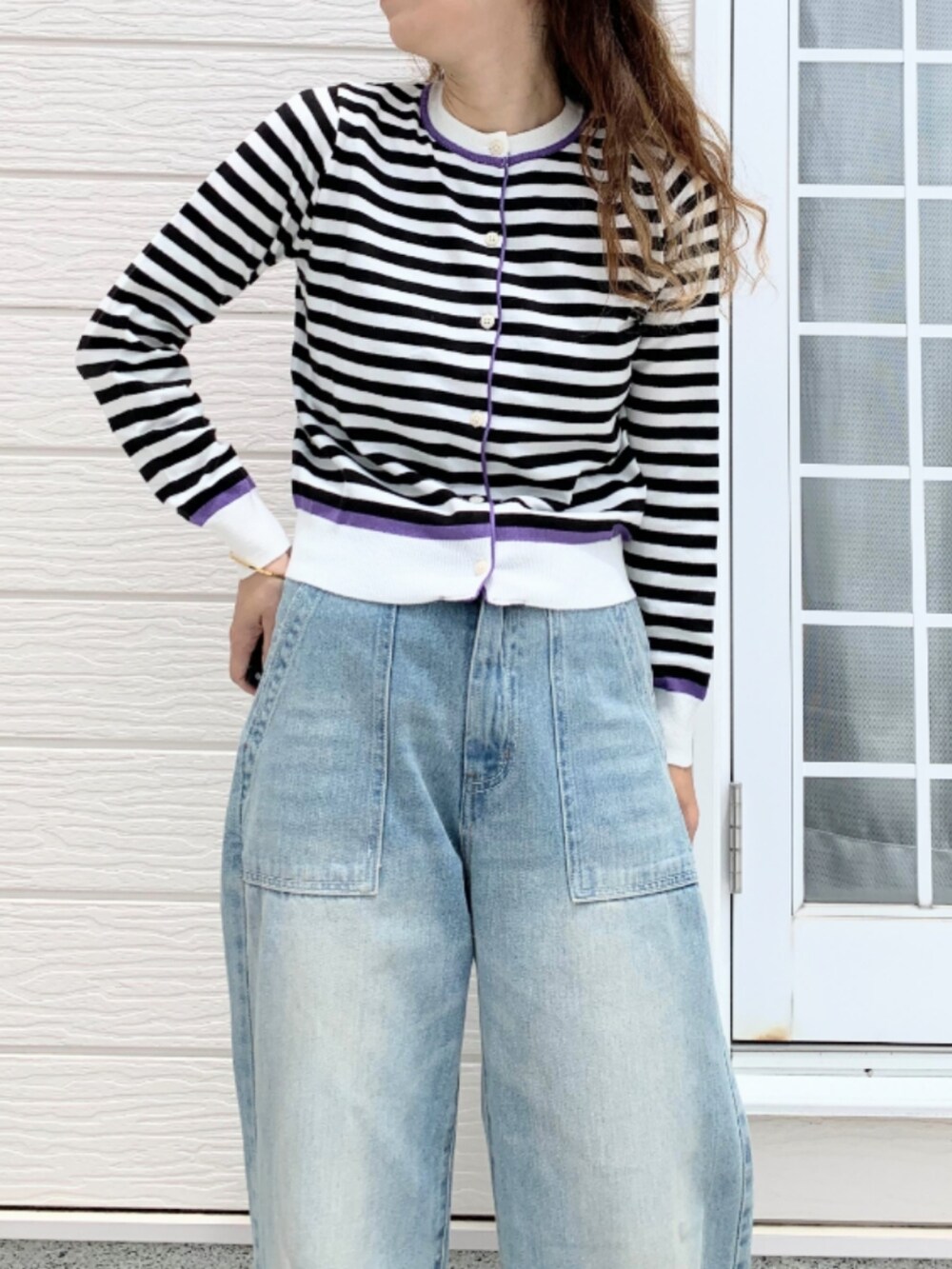 ブルー系のデニムパンツ、ホワイト系のボストンバッグ、ホワイト系のカーディガン/ボレロを着用したレディースの夏コーディネートの4枚目の写真