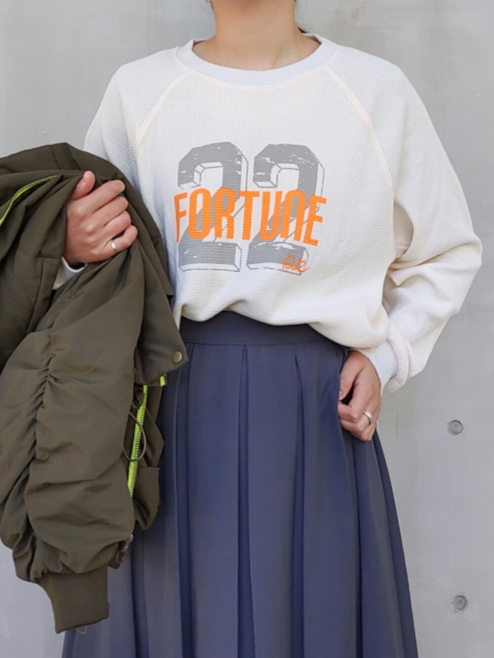 ホワイト系のスニーカー、グリーン系のミリタリージャケット、ホワイト系のTシャツ/カットソーを着用したレディースの秋コーディネートの3枚目の写真