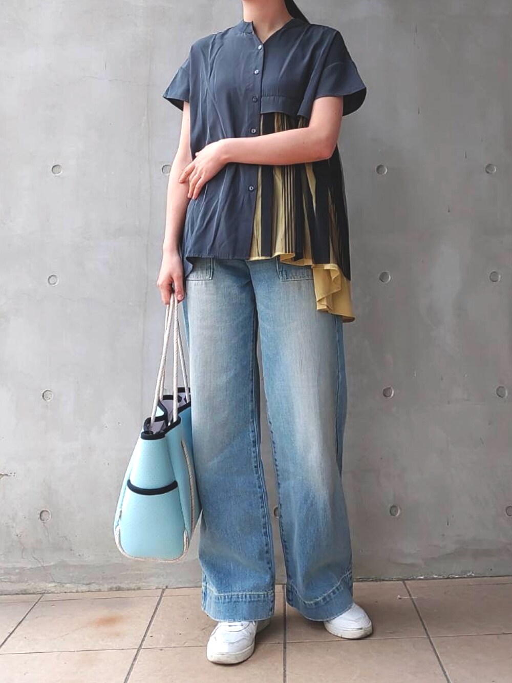ブルー系のデニムパンツ、ブルー系のトートバッグ、ホワイト系のスニーカーを着用したレディースの春コーディネートの3枚目の写真