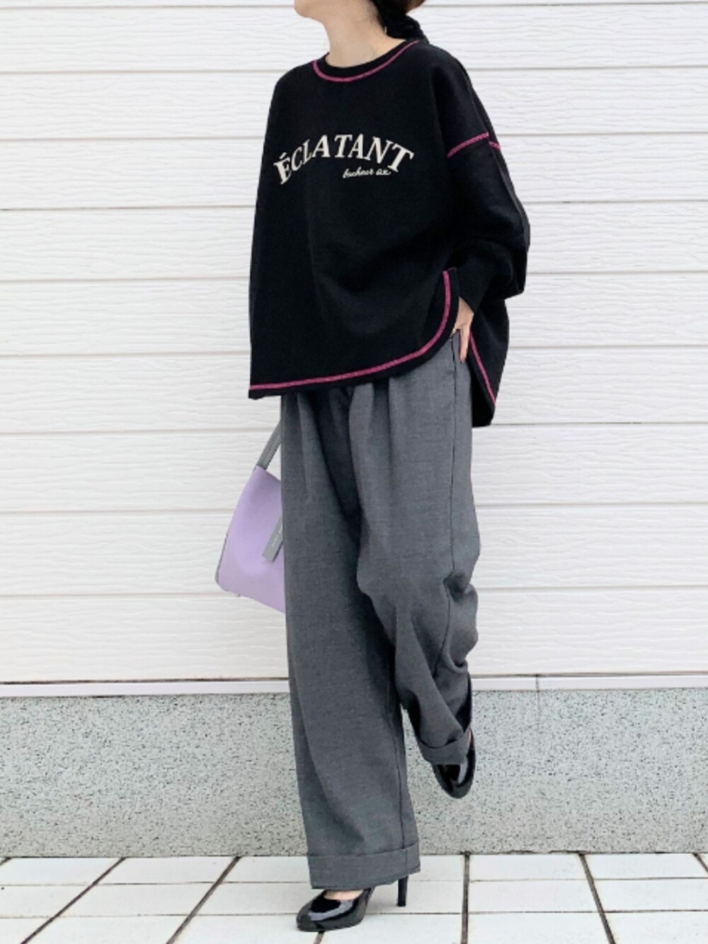 グレー系のスラックス、パープル系のトートバッグ、ブラック系のスウェットを着用したレディースの秋コーディネートの2枚目の写真