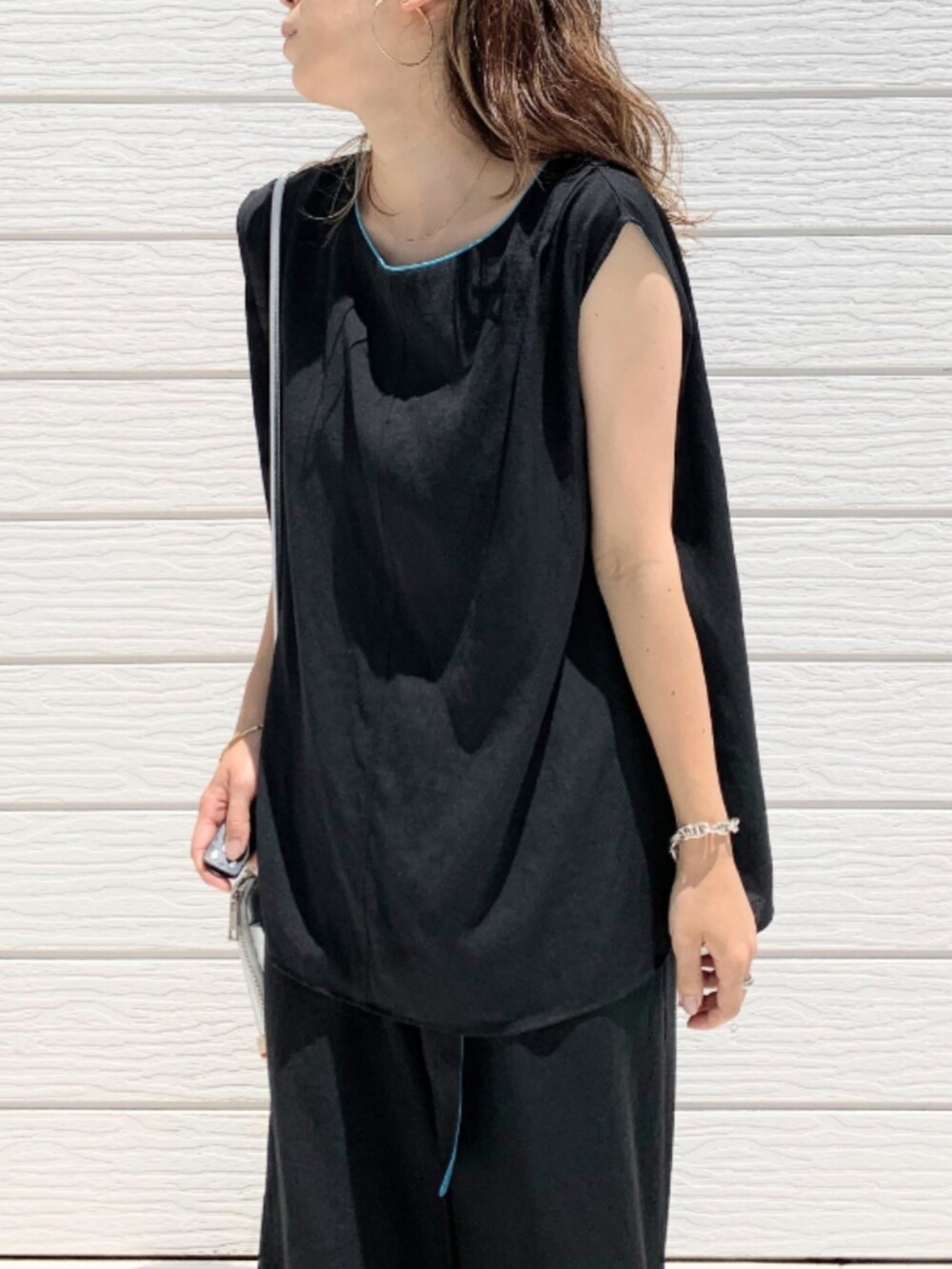 ブラック系のその他パンツ、ブラック系のシャツ/ブラウス、シルバー系のショルダーバッグを着用したレディースの夏コーディネートの4枚目の写真